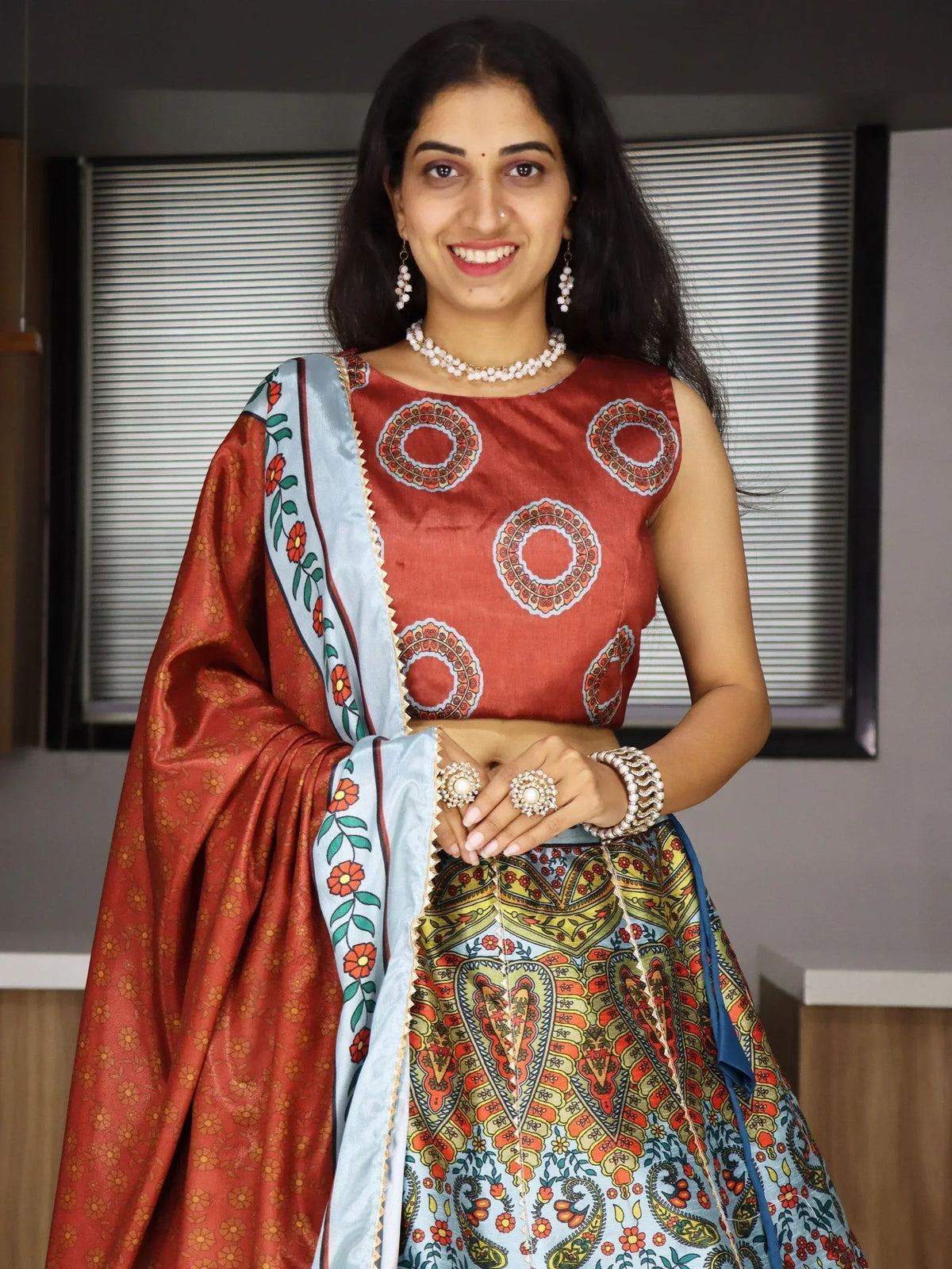 Woman in vibrant Indian ethnic lehenga choli with floral and paisley prints, perfect for festive occasions.