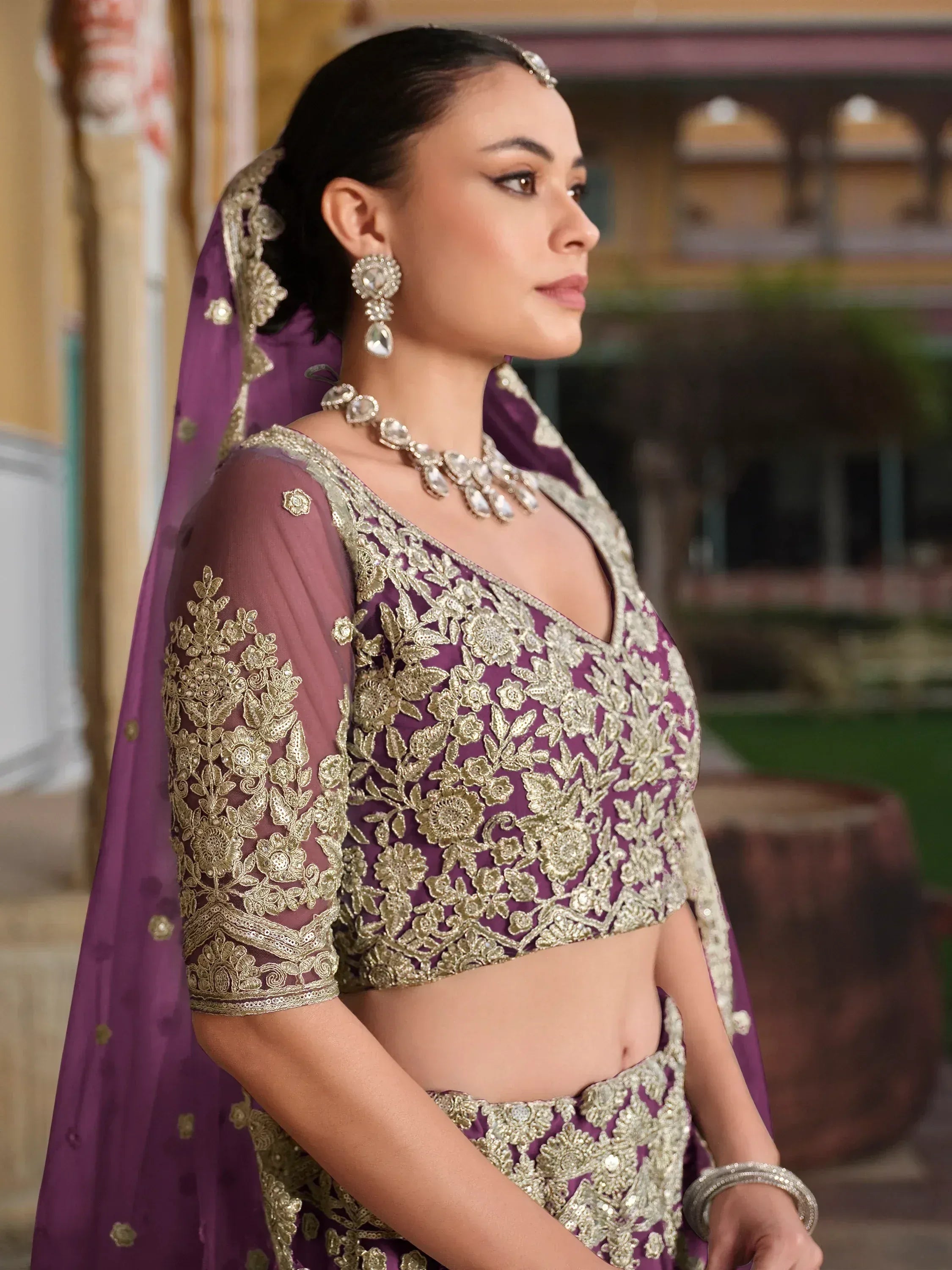 Purple designer lehenga choli with gold embroidery, perfect for Indian weddings and festive occasions.