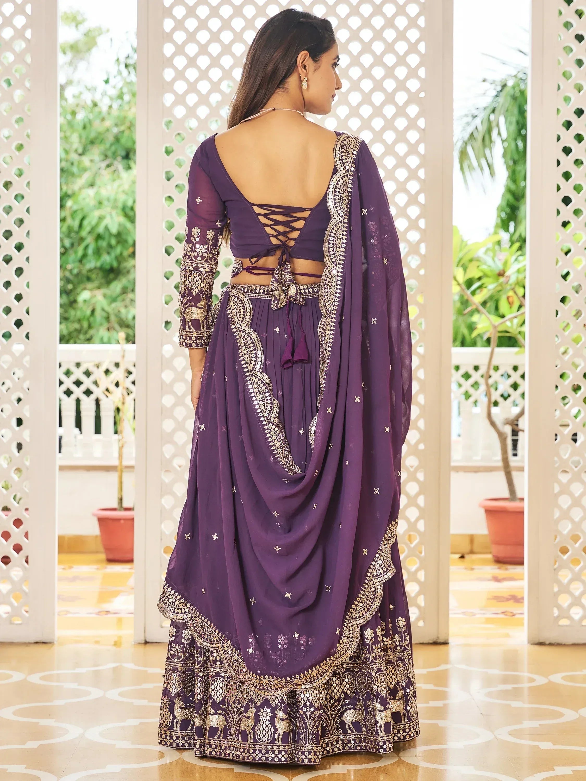 Purple embroidered lehenga choli with gold deer motifs and back tie detail, ideal for Indian ethnic occasions