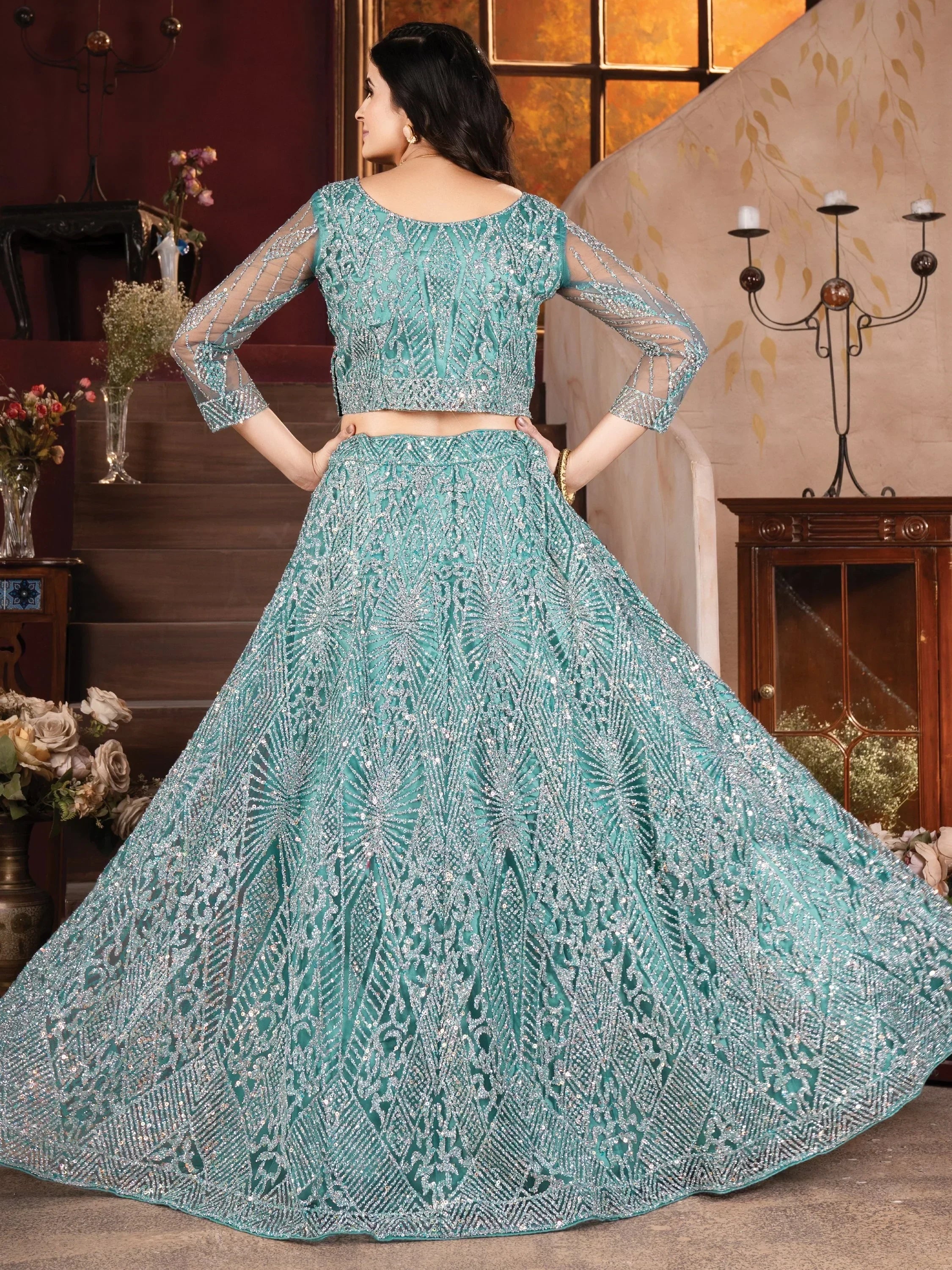Teal designer lehenga choli with heavy silver embroidery and sheer sleeves, perfect for weddings and parties.