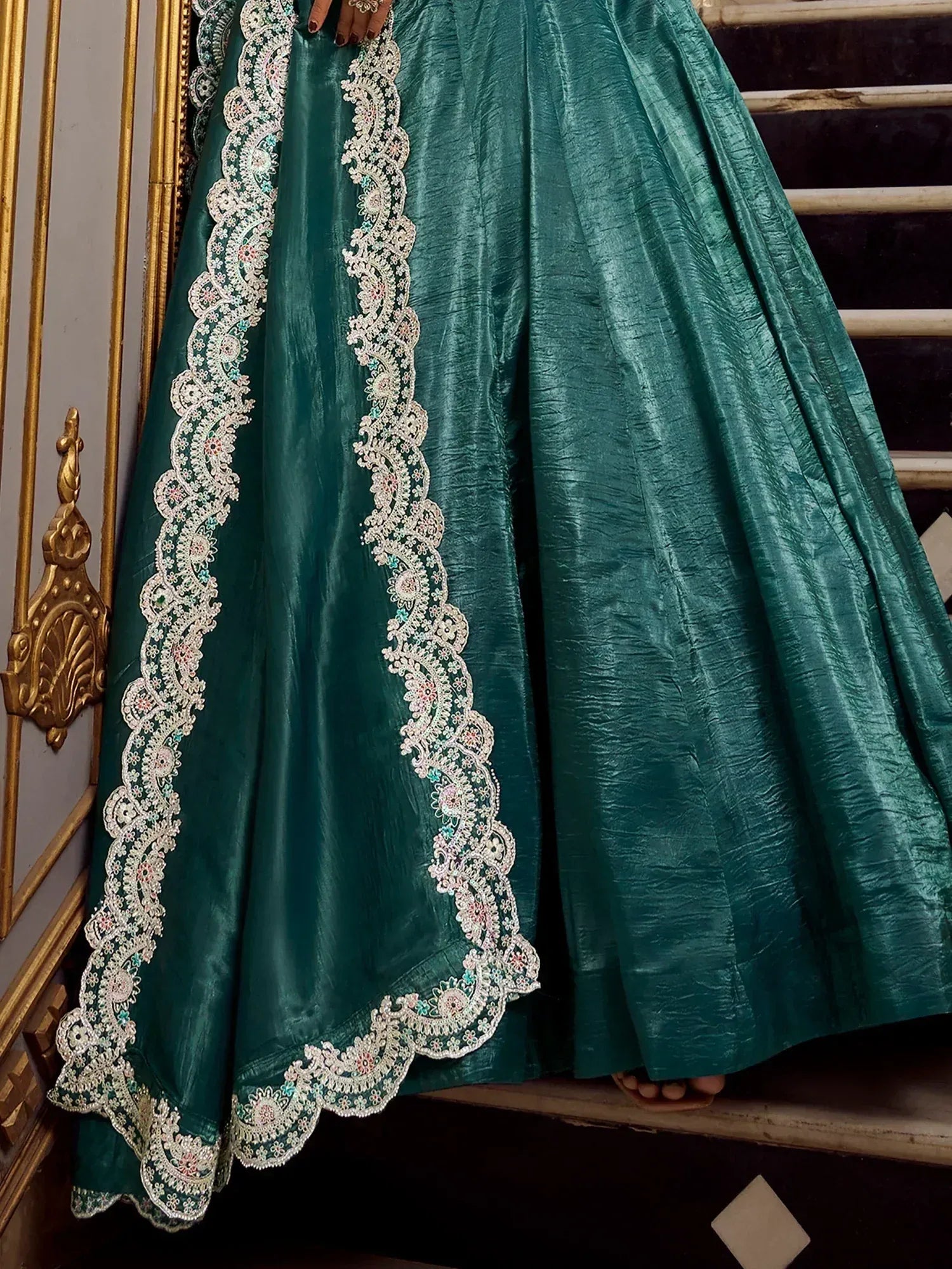 Emerald green lehenga with intricate white floral embroidery and scalloped border, perfect for Indian ethnic wear.
