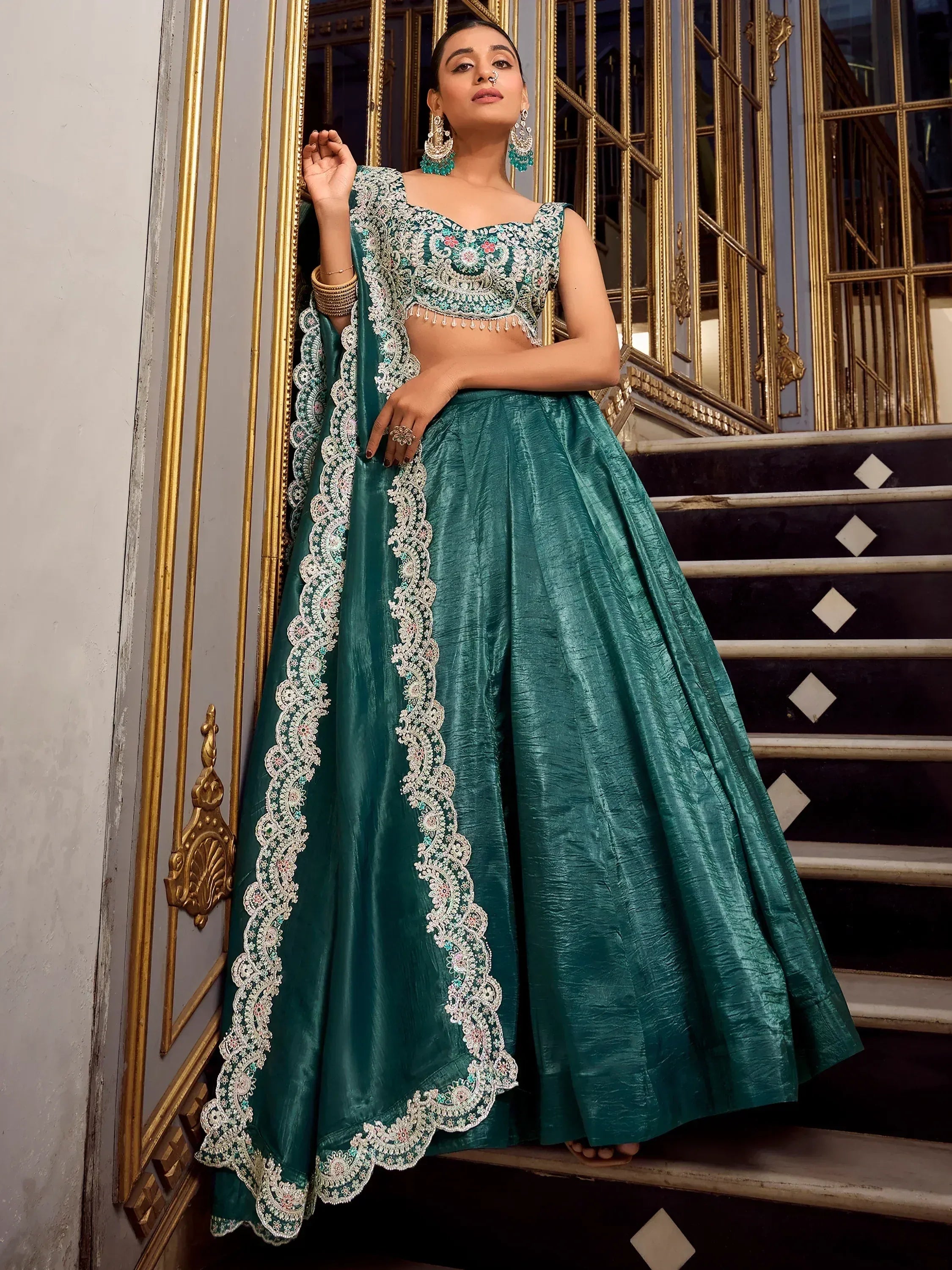 Teal green embroidered lehenga choli with floral lace, perfect for Indian weddings and festive occasions.