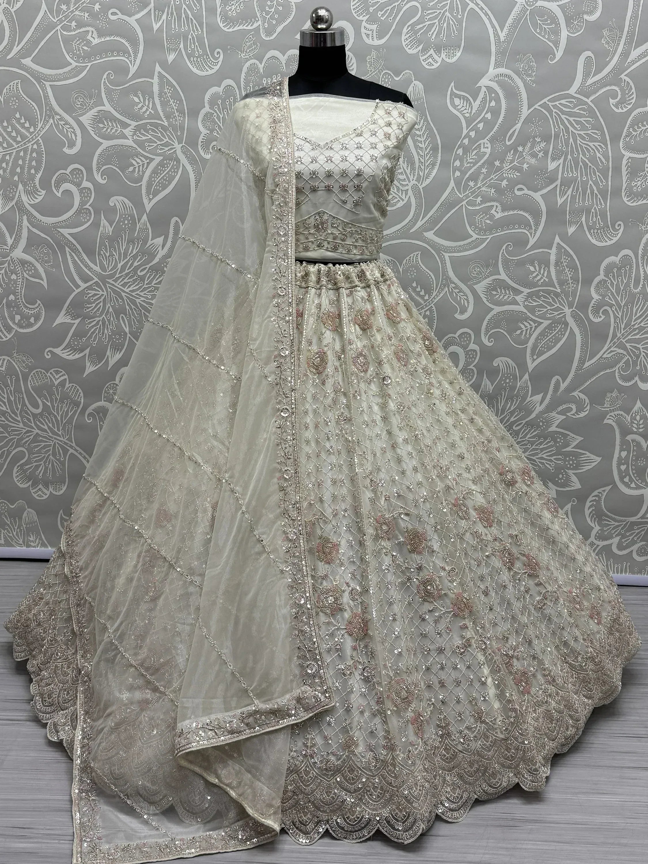 Ivory designer lehenga choli with intricate embroidery and net dupatta, perfect for weddings and festive occasions