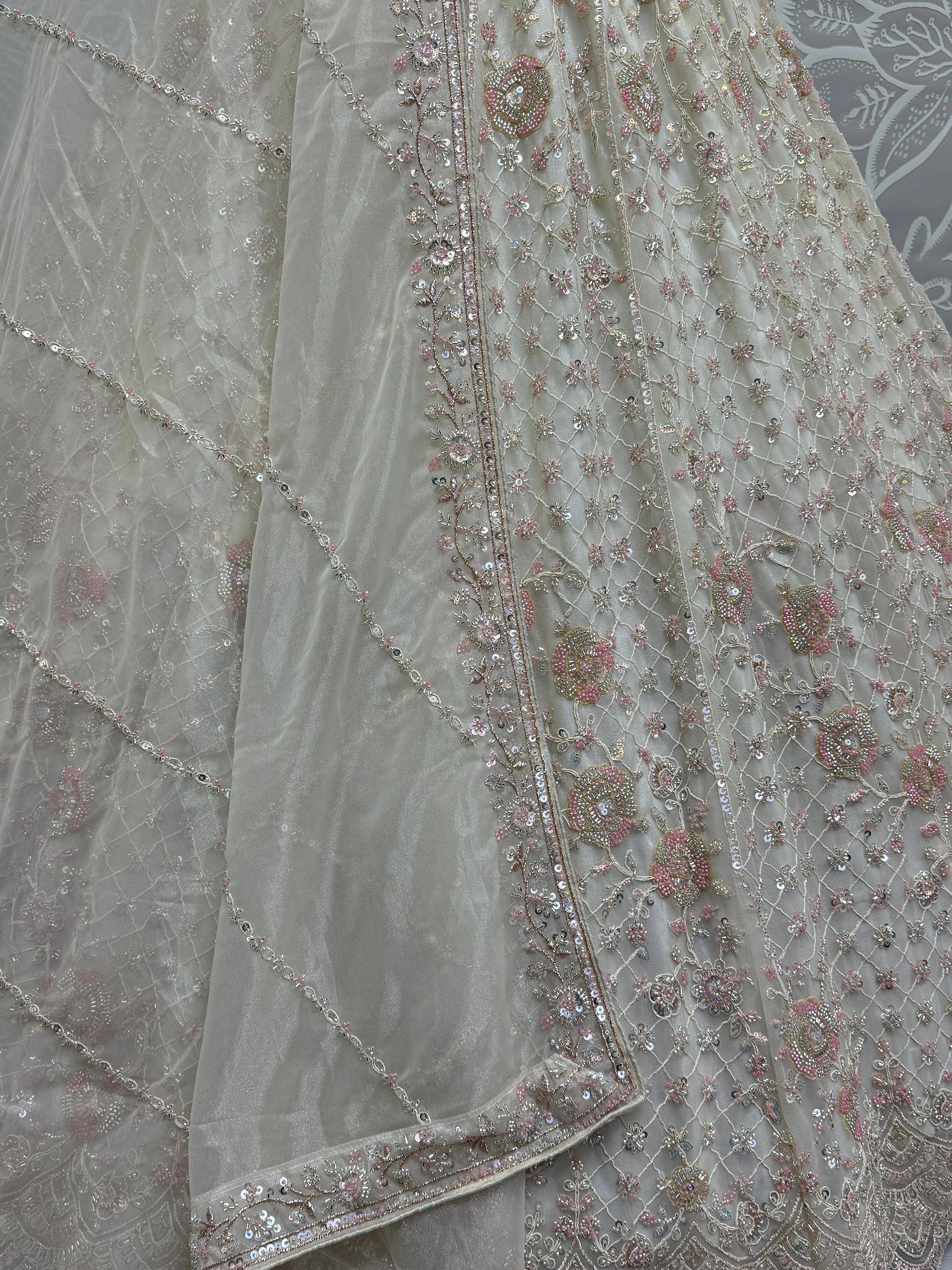Elegant beige lehenga with pink and gold floral embroidery and sequin detailing for Indian ethnic wear.