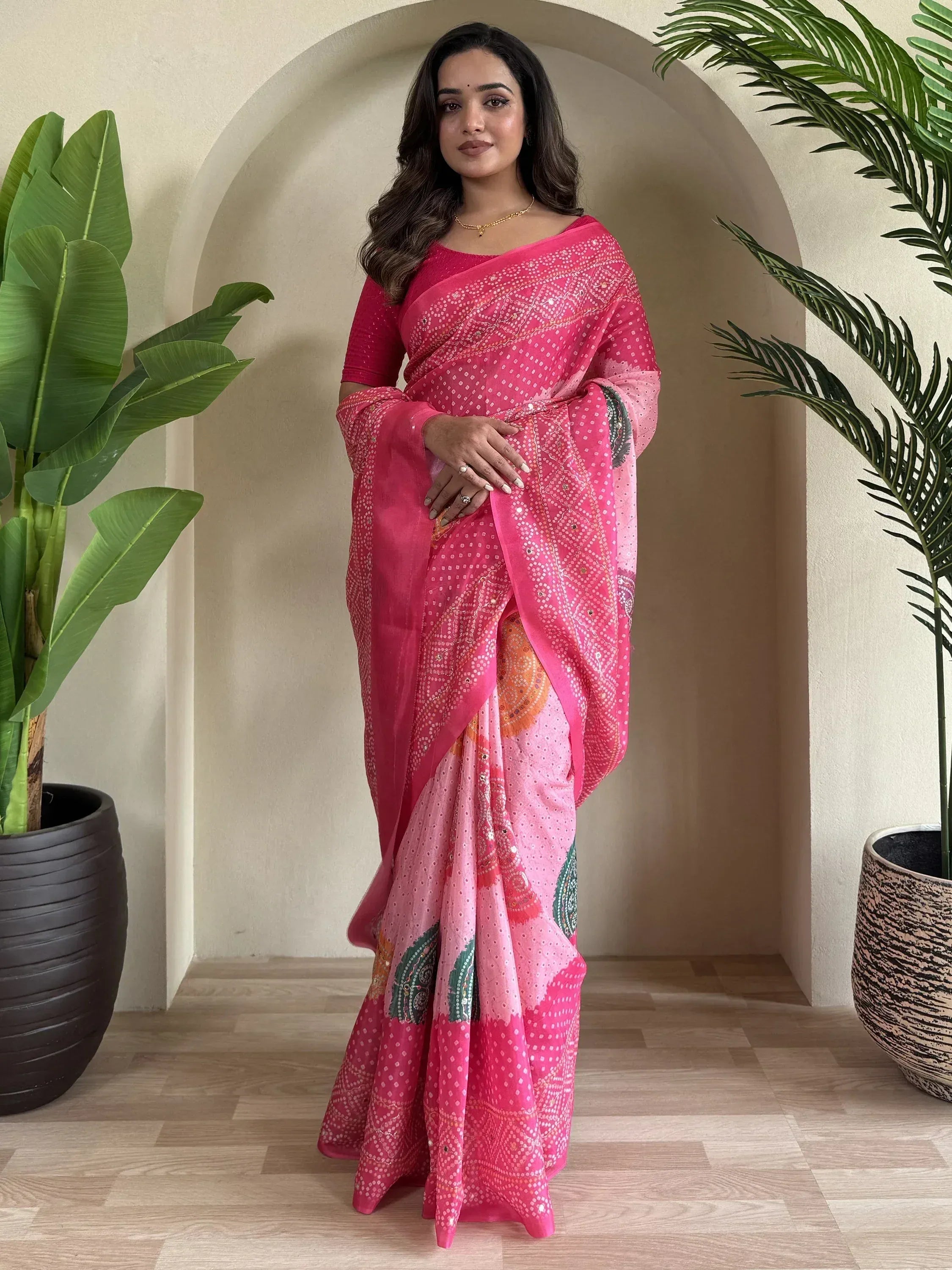 Woman in pink embroidered saree with floral patterns, styled for Indian ethnic wear occasions