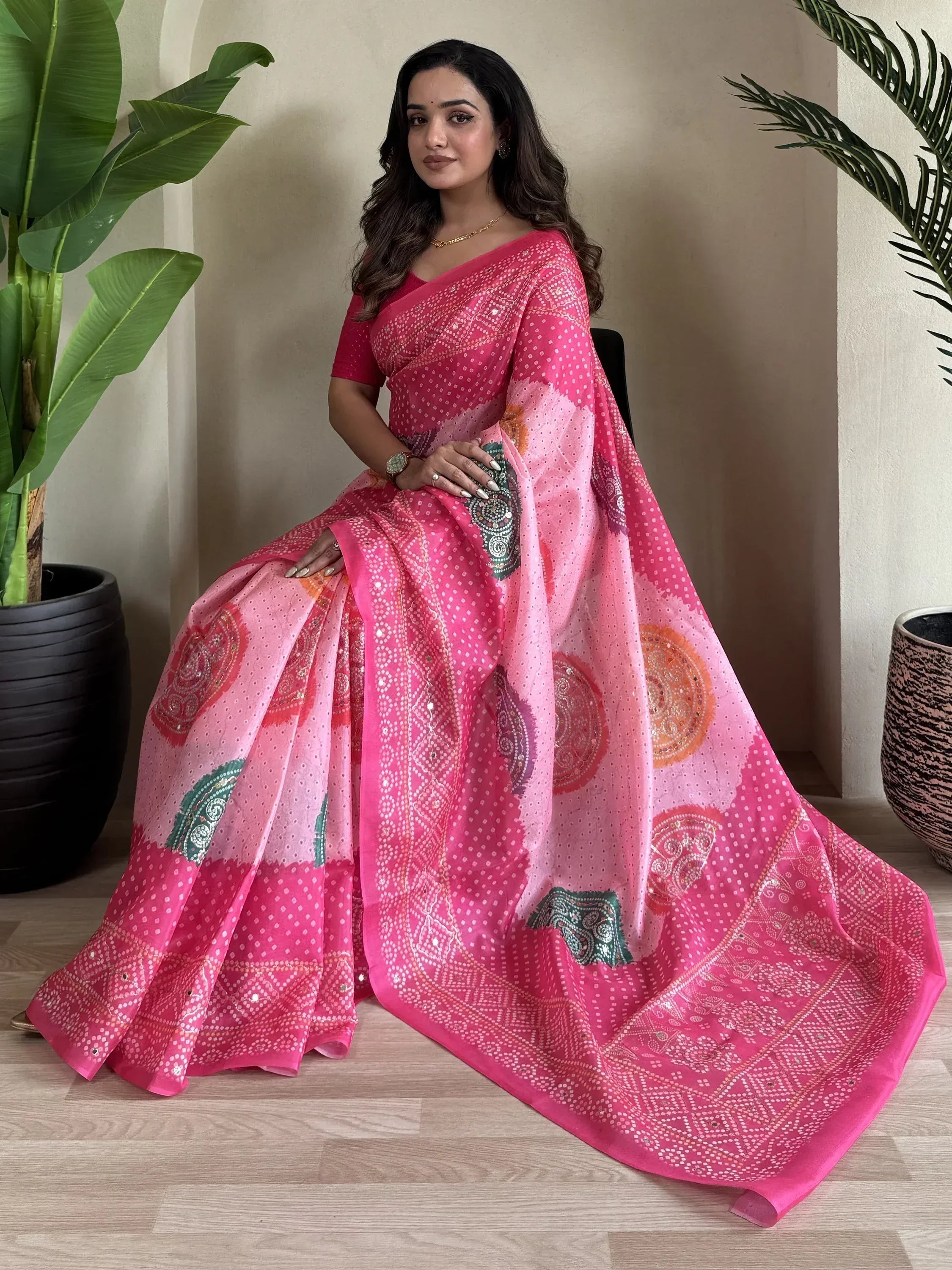 Woman in vibrant pink printed saree with mirror work, styled for Indian ethnic wear occasions
