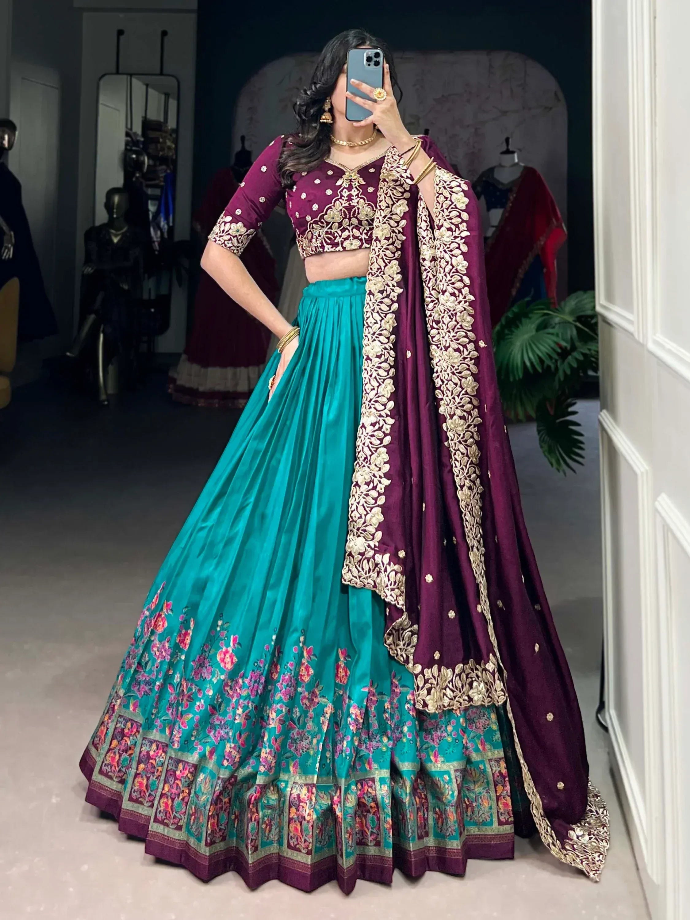 Elegant teal and maroon lehenga choli with gold embroidery, floral border, perfect for Indian weddings and festive occasions.