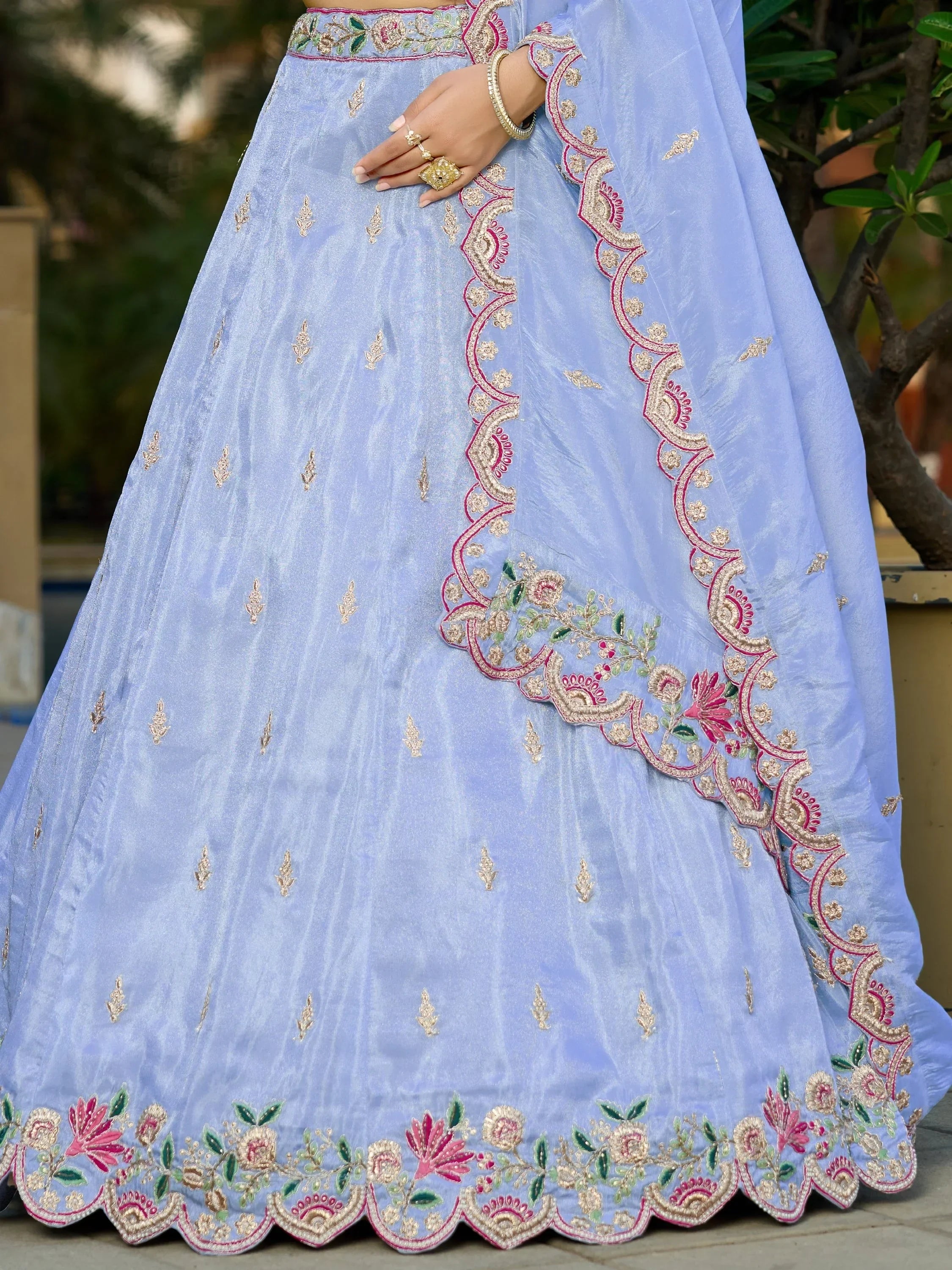 Light blue embroidered lehenga with floral gold and pink detailing, perfect for Indian ethnic wear occasions.