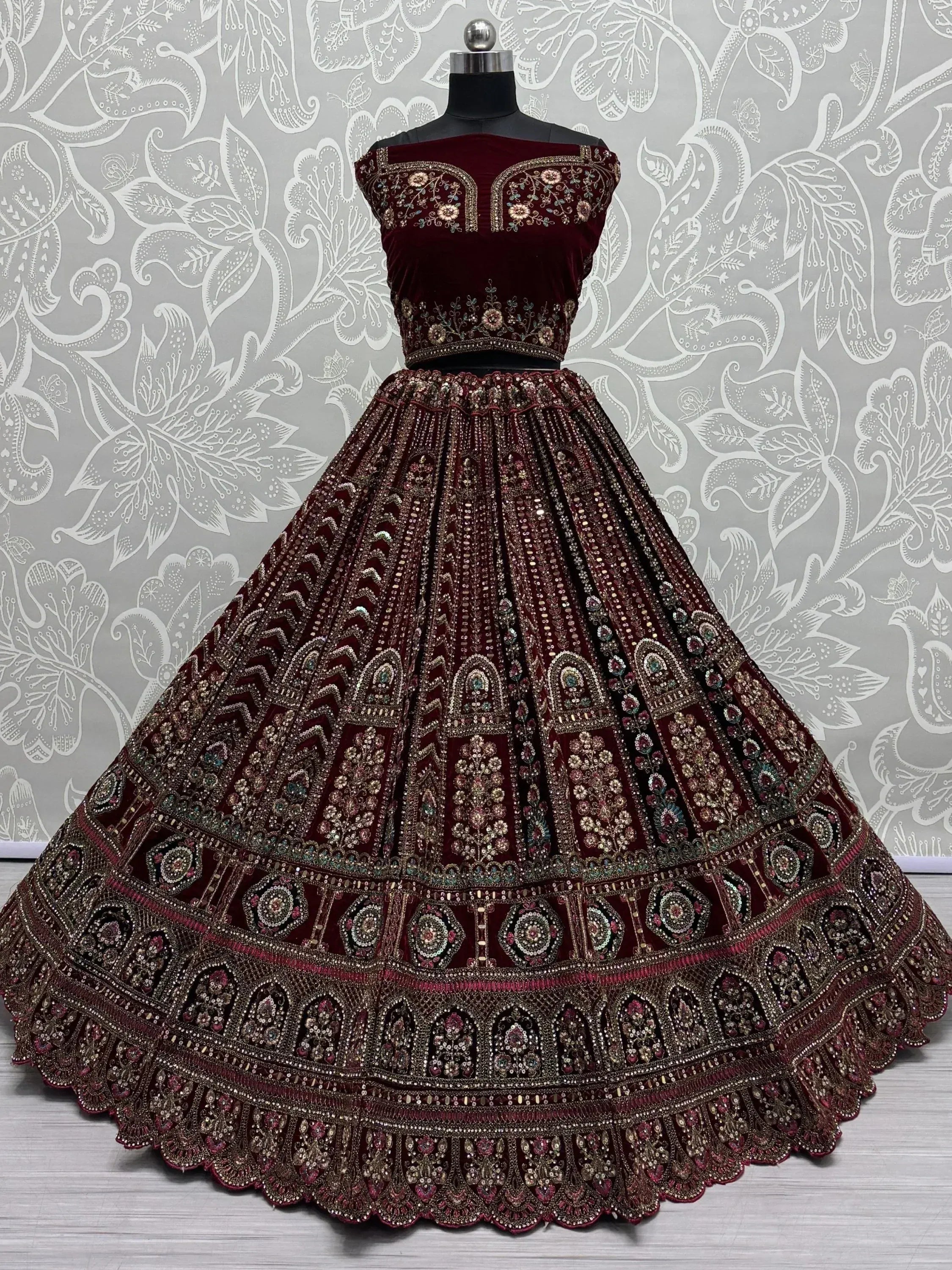 Burgundy velvet lehenga choli with heavy embroidery and sequin work, perfect for Indian weddings and festive occasions.