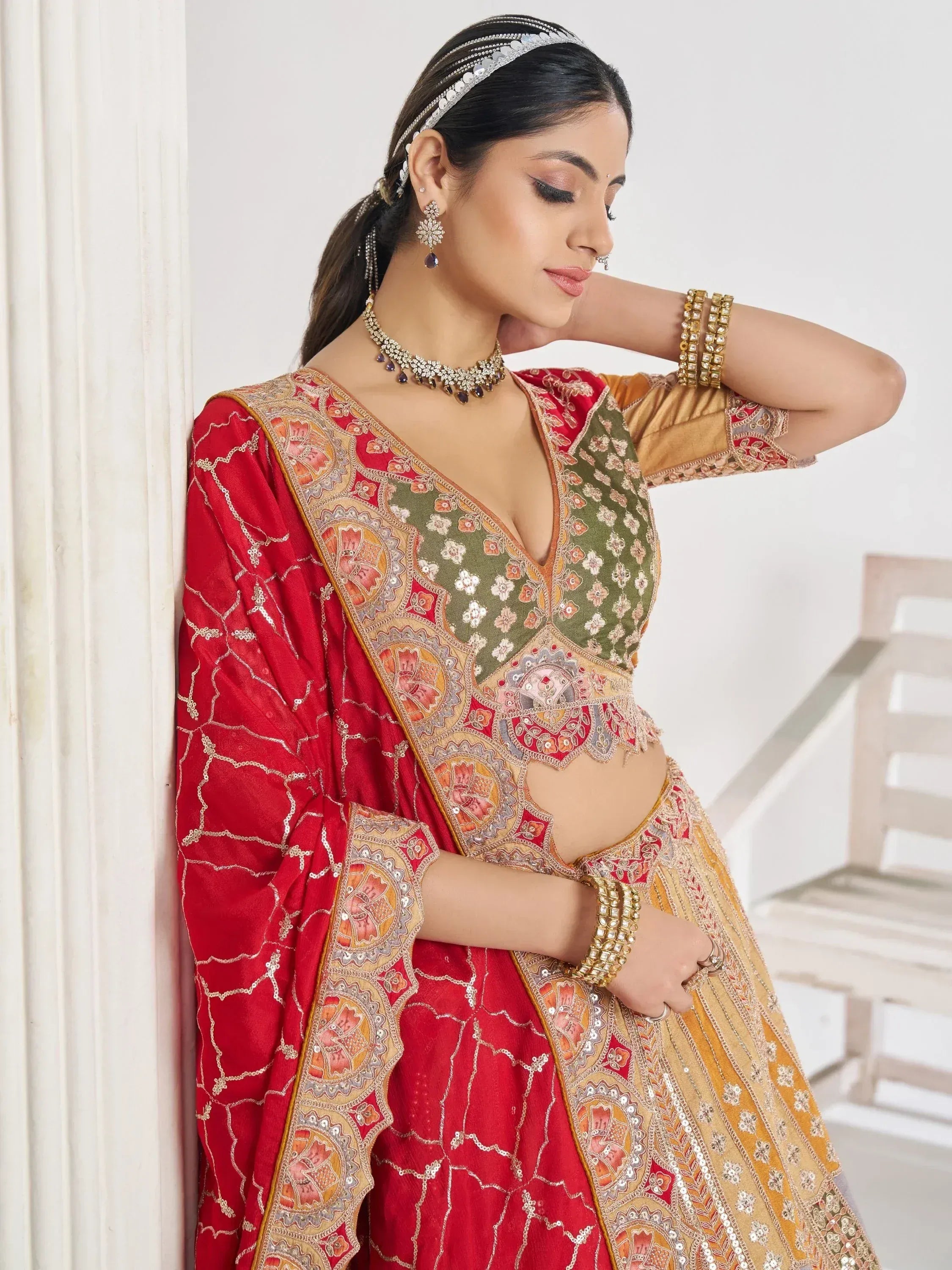 Red and gold embroidered lehenga choli with floral motifs, perfect for Indian weddings and festive occasions.
