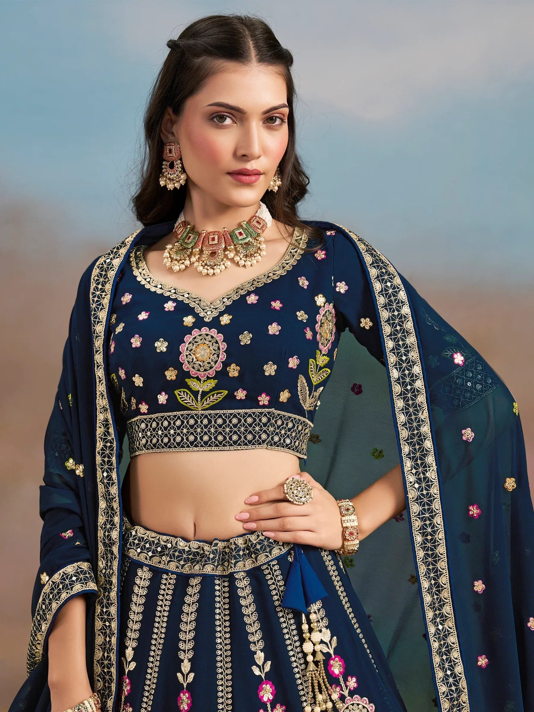 Navy blue embroidered lehenga choli with floral motifs and gold detailing, perfect for Indian ethnic occasions.