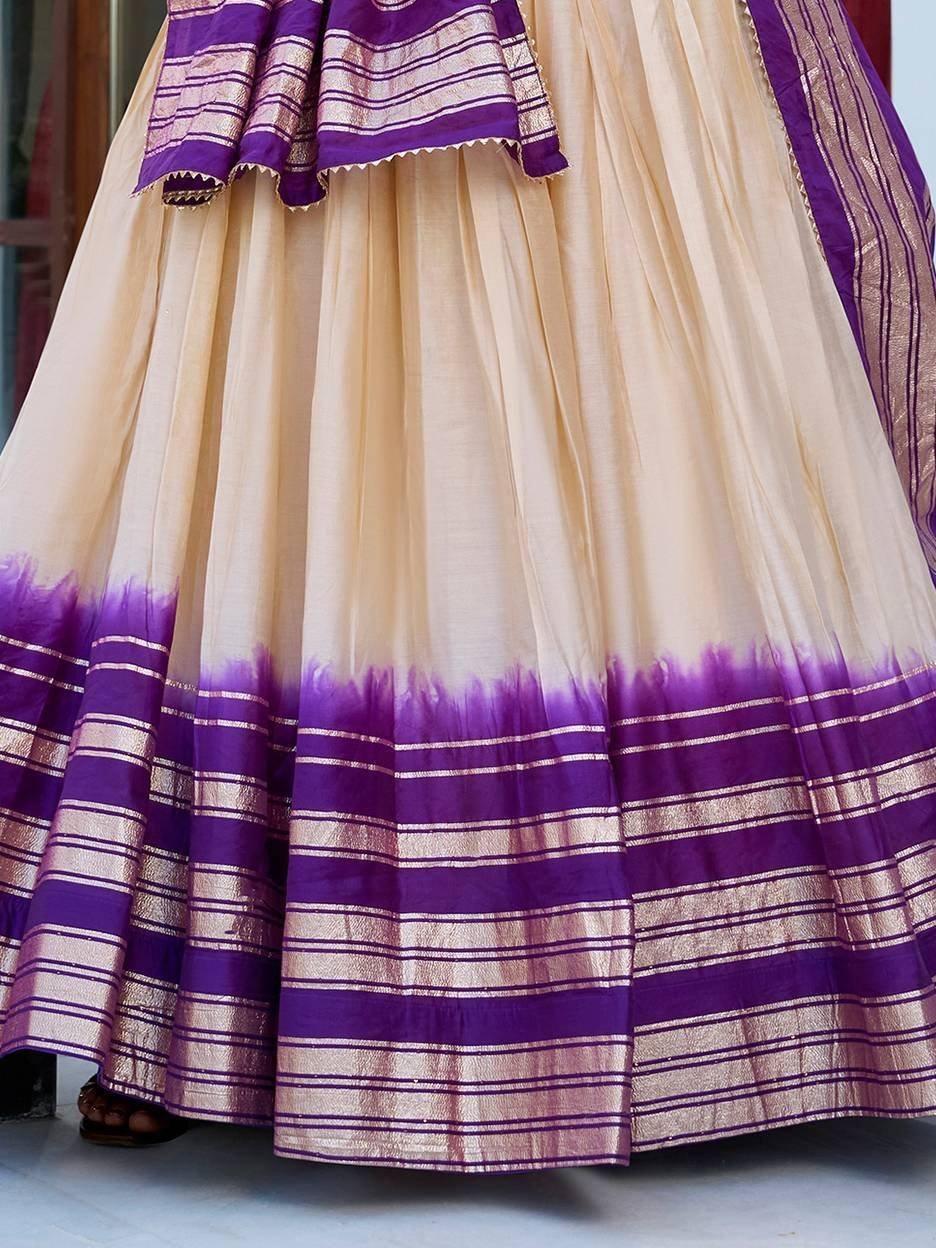 Cream and purple ethnic lehenga with striped border and tie-dye hem, perfect for Indian weddings and festivals