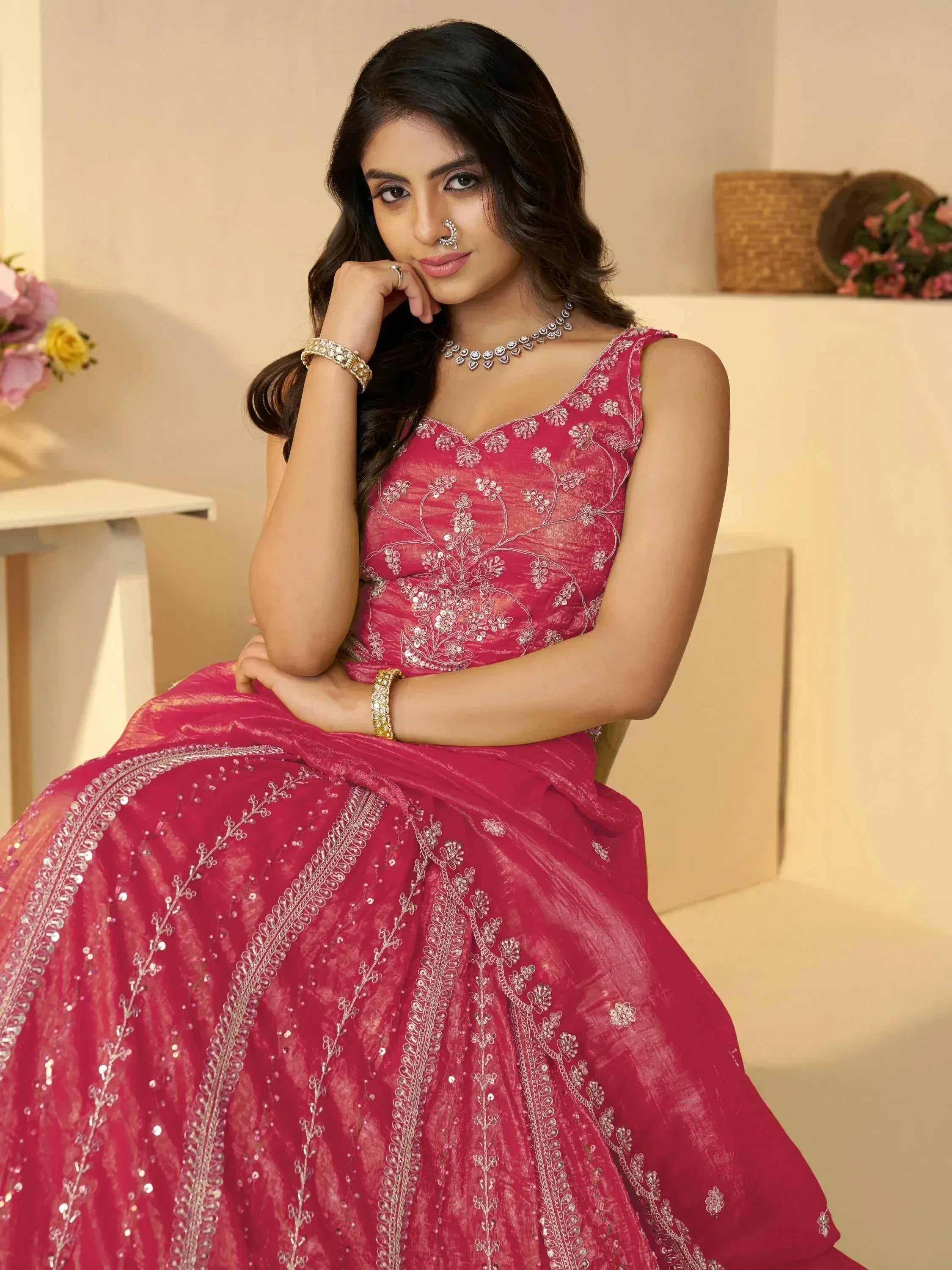 Woman in pink embroidered lehenga choli with silver detailing, perfect for Indian ethnic occasions