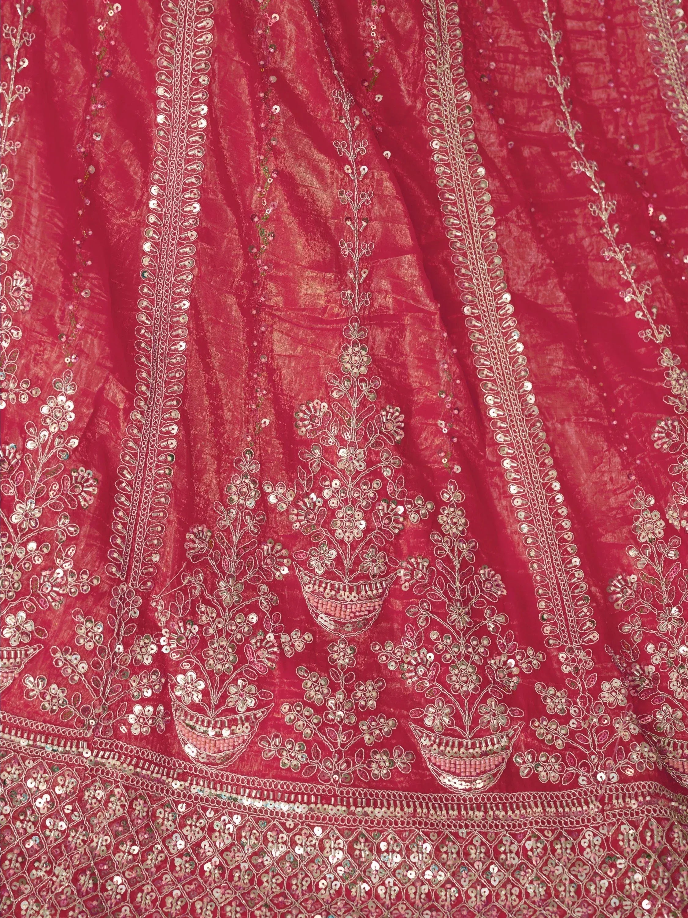 Red ethnic lehenga with intricate mirror and sequin embroidery, floral motifs, and detailed border work