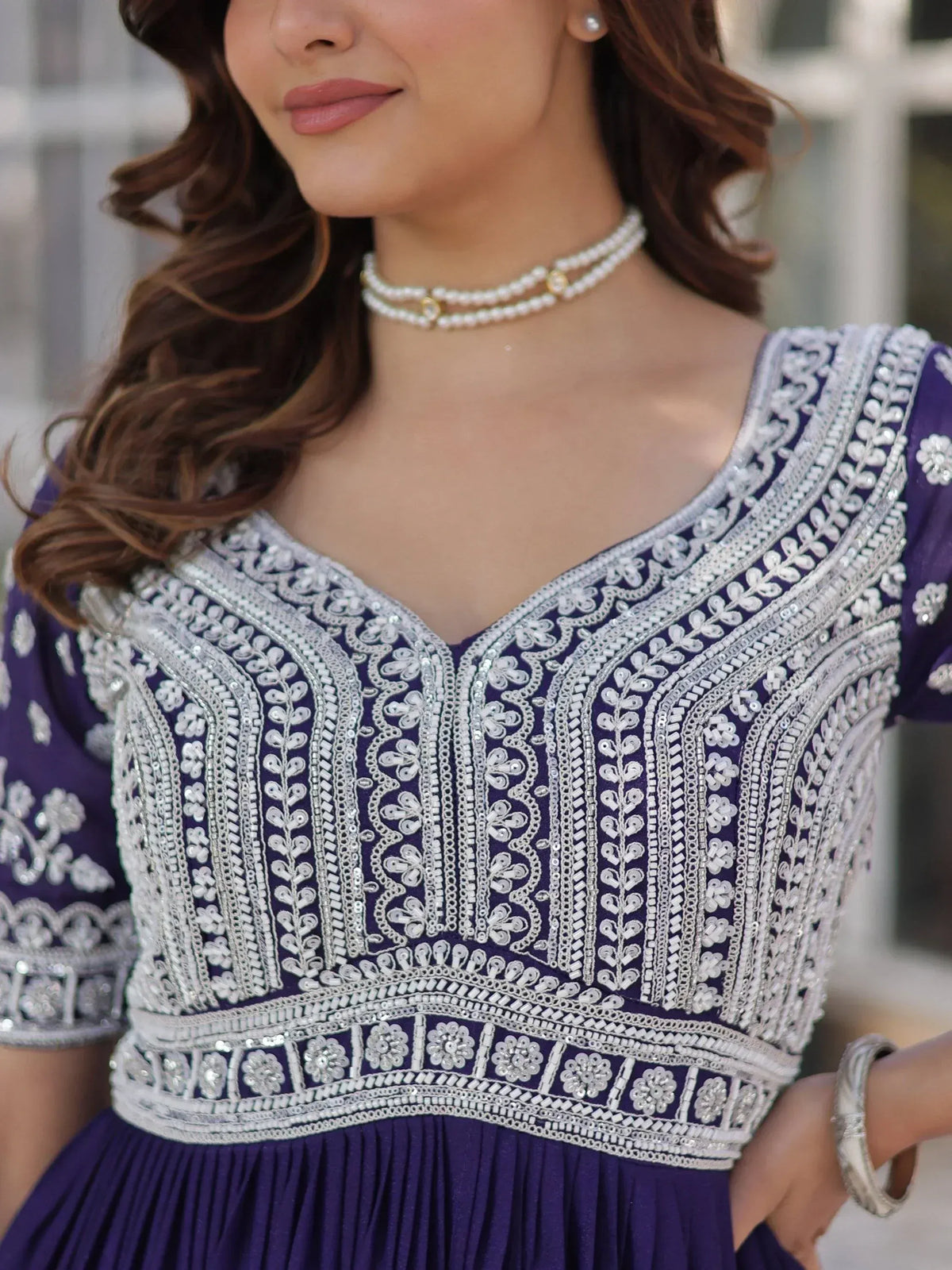 Purple ethnic gown with intricate white embroidery and pearl necklace, perfect for Indian occasions