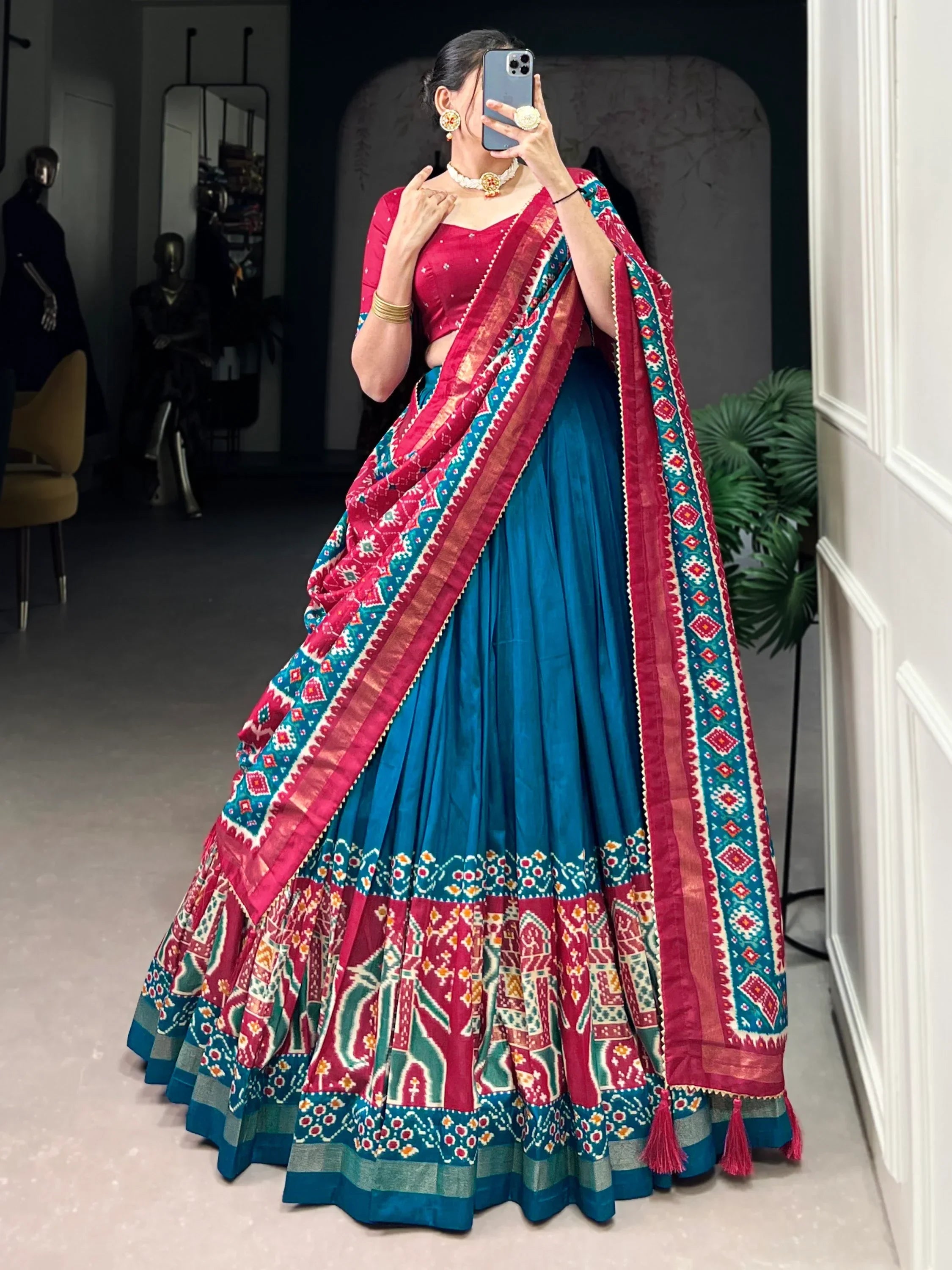 Woman in vibrant blue and pink printed lehenga choli with ethnic patterns, perfect for Indian festivals and weddings.