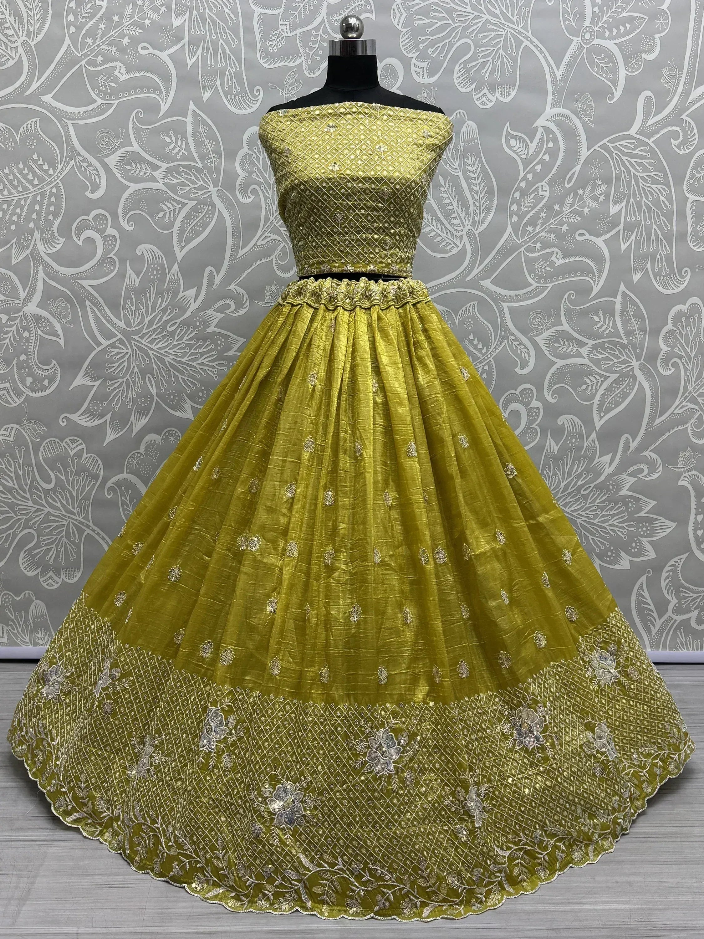 Yellow designer lehenga choli with intricate embroidery and net skirt, perfect for Indian ethnic wear occasions.