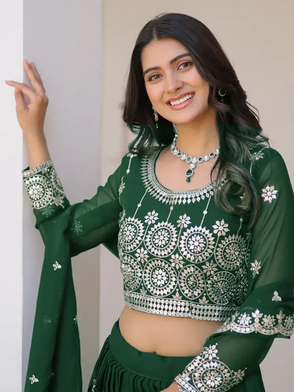 Green embroidered ethnic crop top with mirror work, paired with matching skirt for Indian festive wear