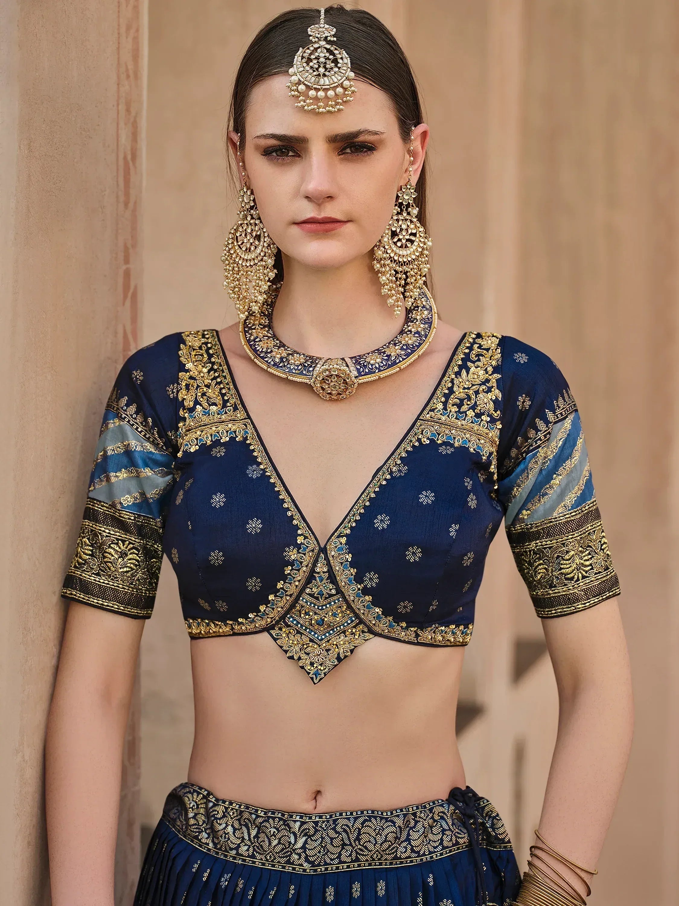 Navy blue designer lehenga choli with gold embroidery and traditional Indian jewelry