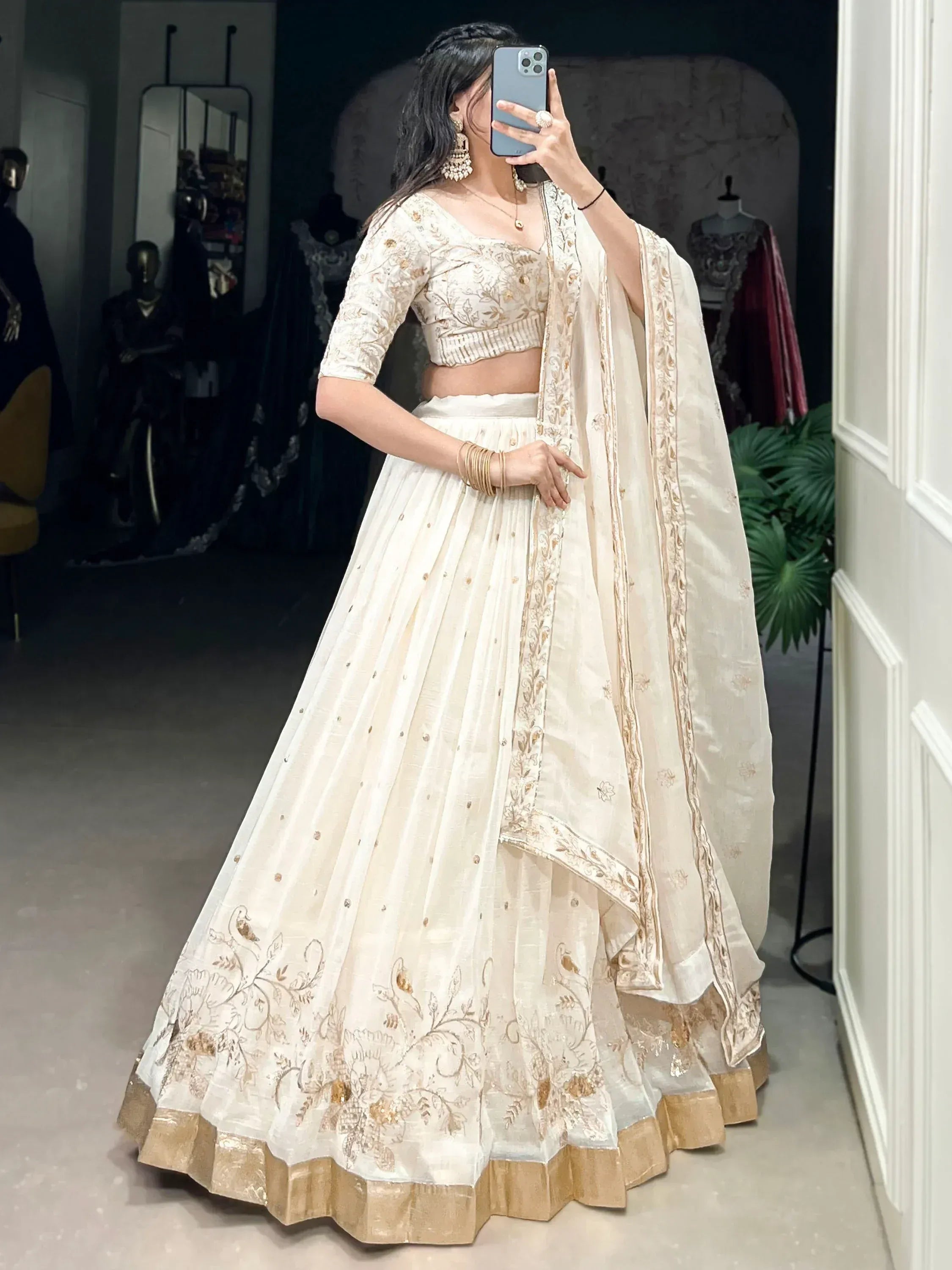 Cream embroidered lehenga choli with gold detailing, perfect for Indian weddings and festive occasions.