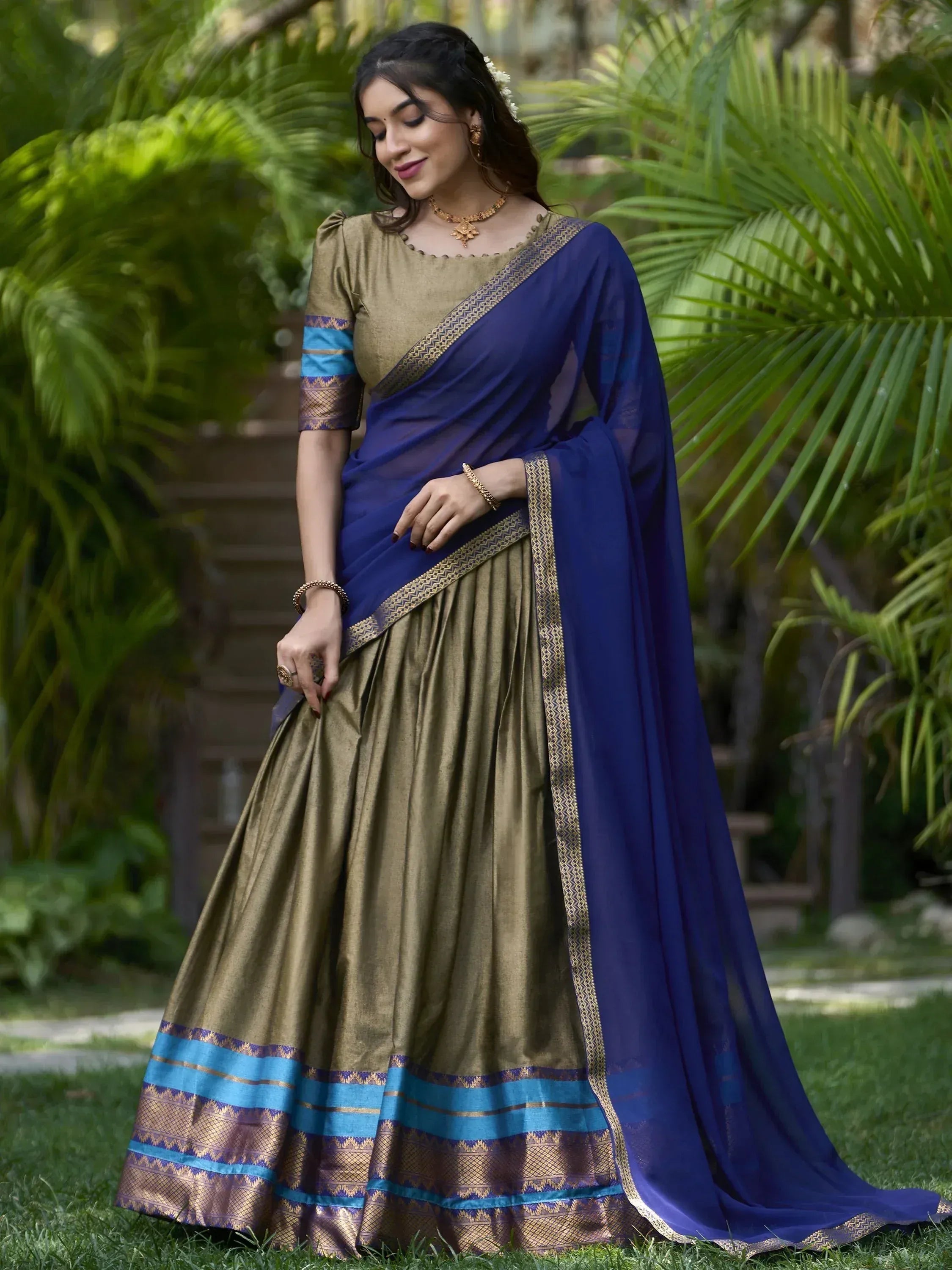 Woman in elegant blue and gold designer saree with intricate border, perfect for Indian ethnic occasions