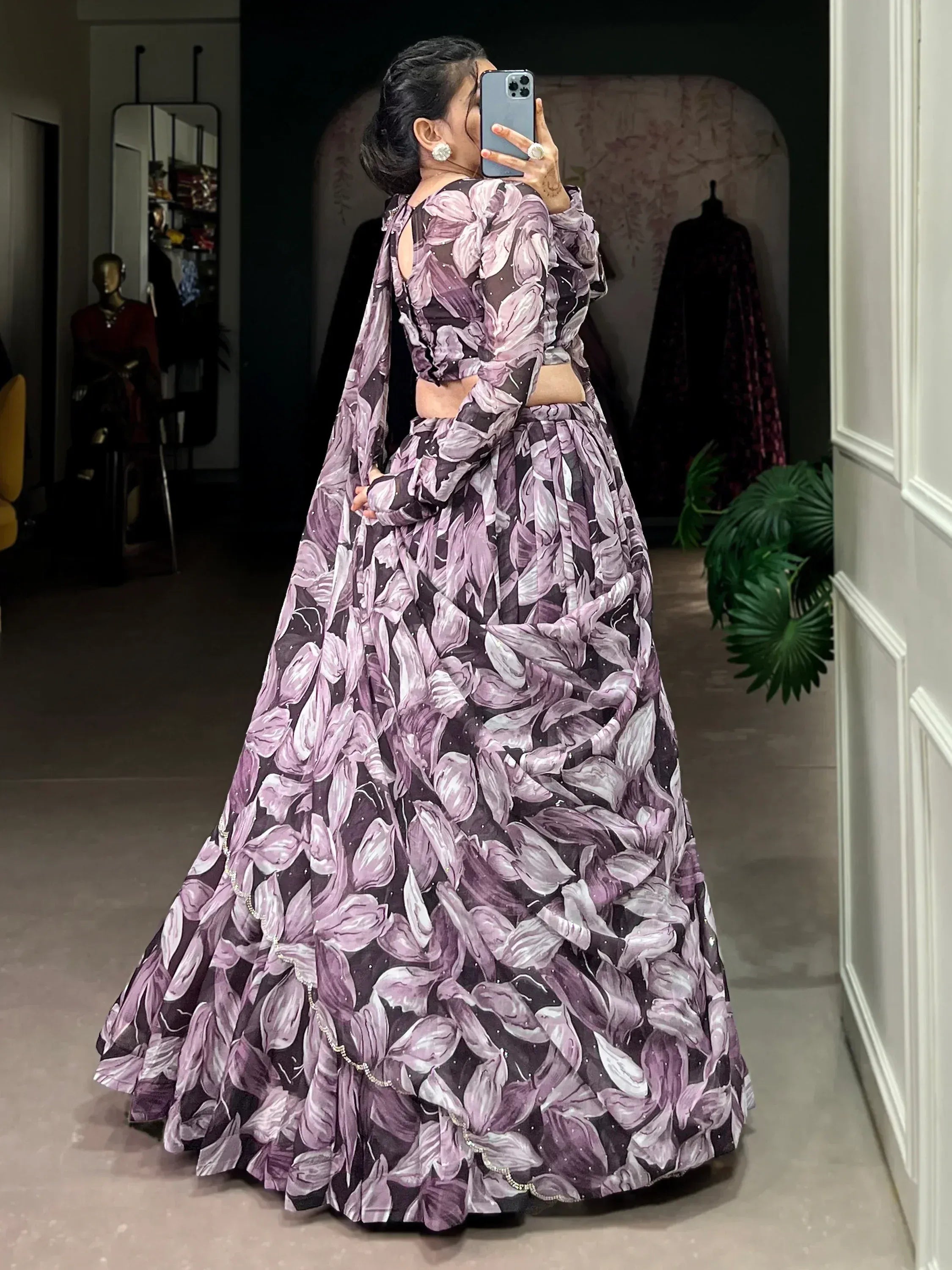 Purple floral print lehenga choli with long sleeves and mirror selfie in boutique
