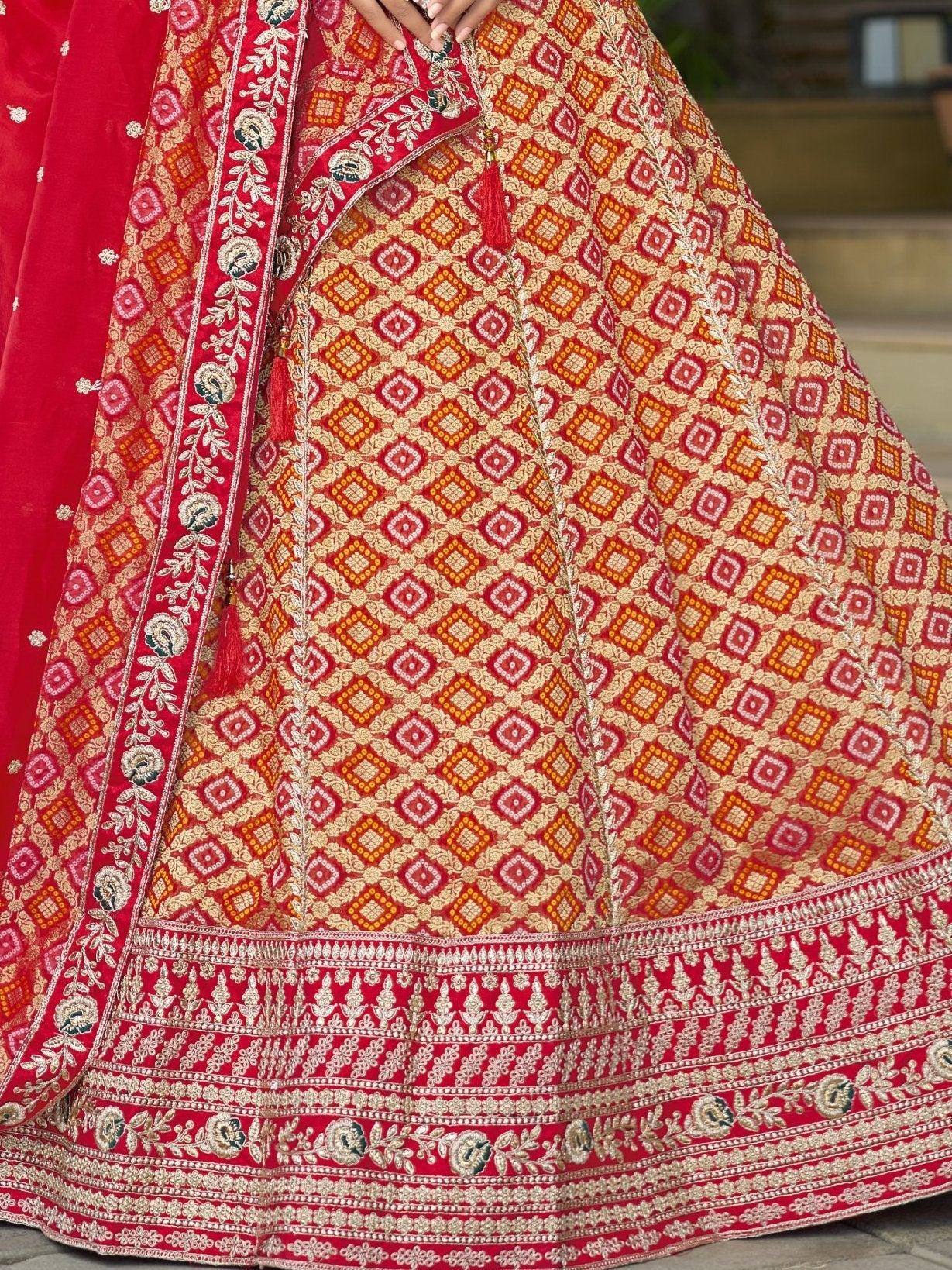 Red and gold embroidered lehenga choli with geometric patterns and floral border, perfect for Indian ethnic wear.