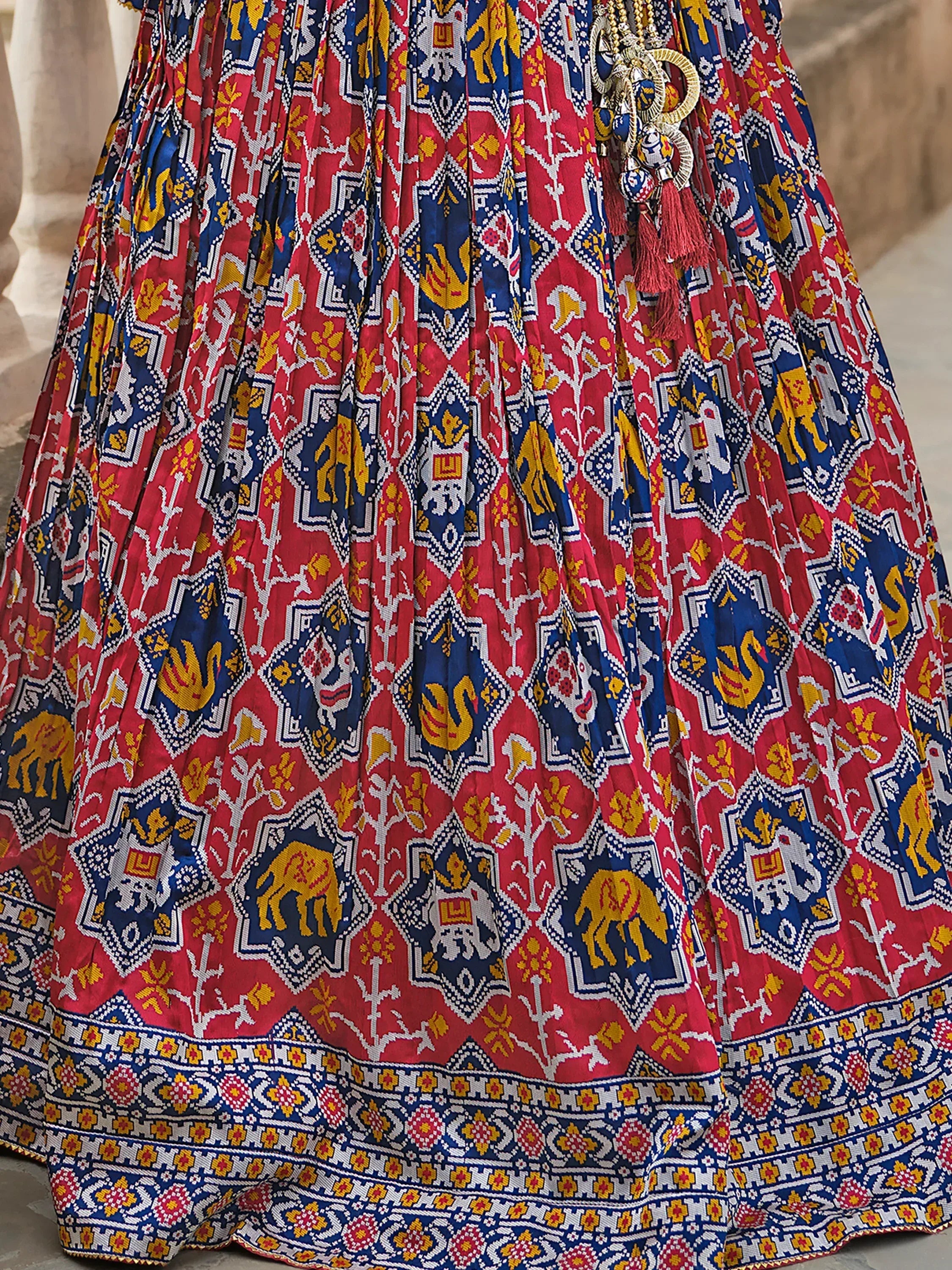 Vibrant red and blue printed lehenga skirt with elephant motifs and tassel detailing, ideal for Indian ethnic wear.