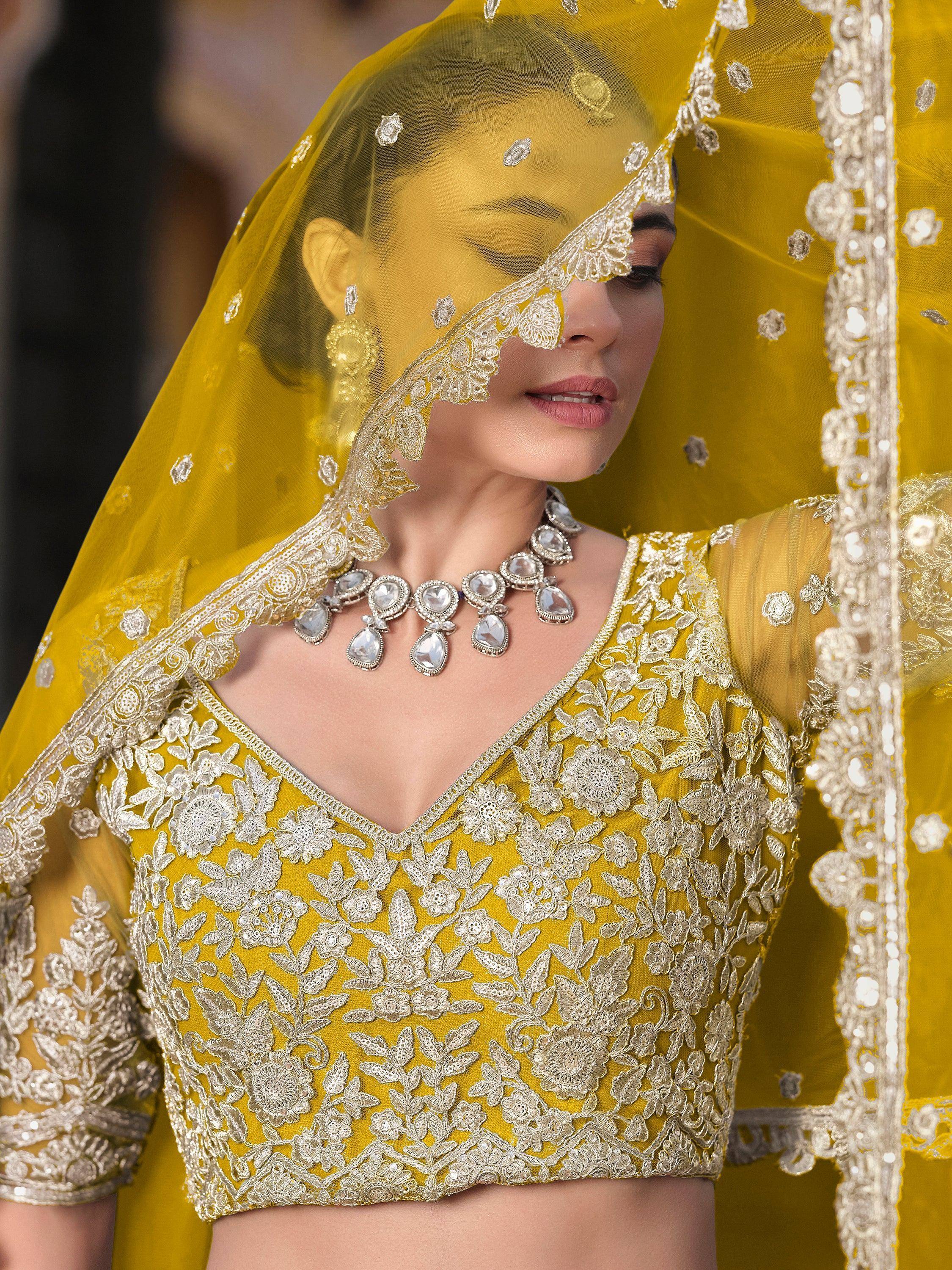 Yellow embroidered lehenga choli with floral lace and dupatta, perfect for Indian weddings and festive occasions.