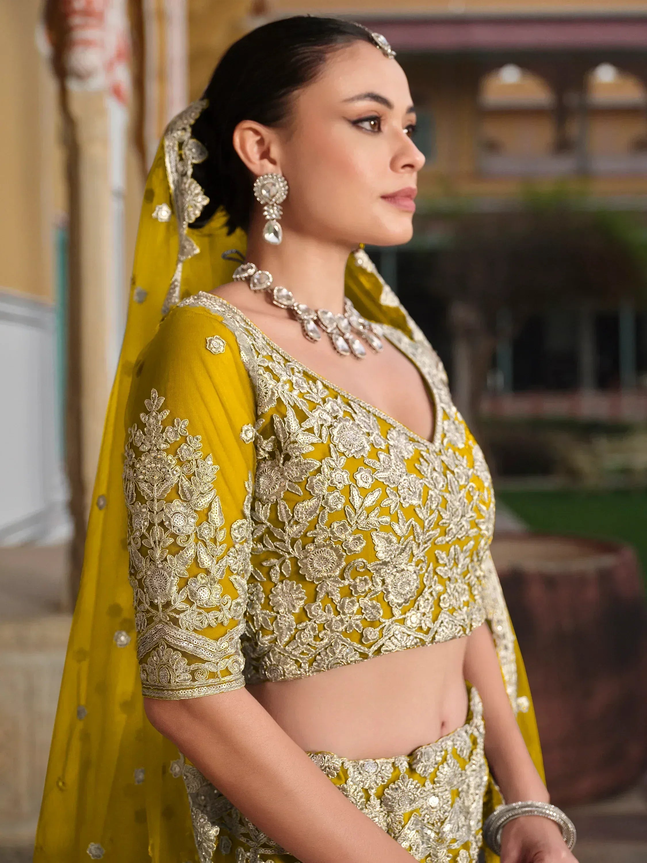 Yellow designer lehenga choli with silver embroidery, perfect for Indian weddings and ethnic events.