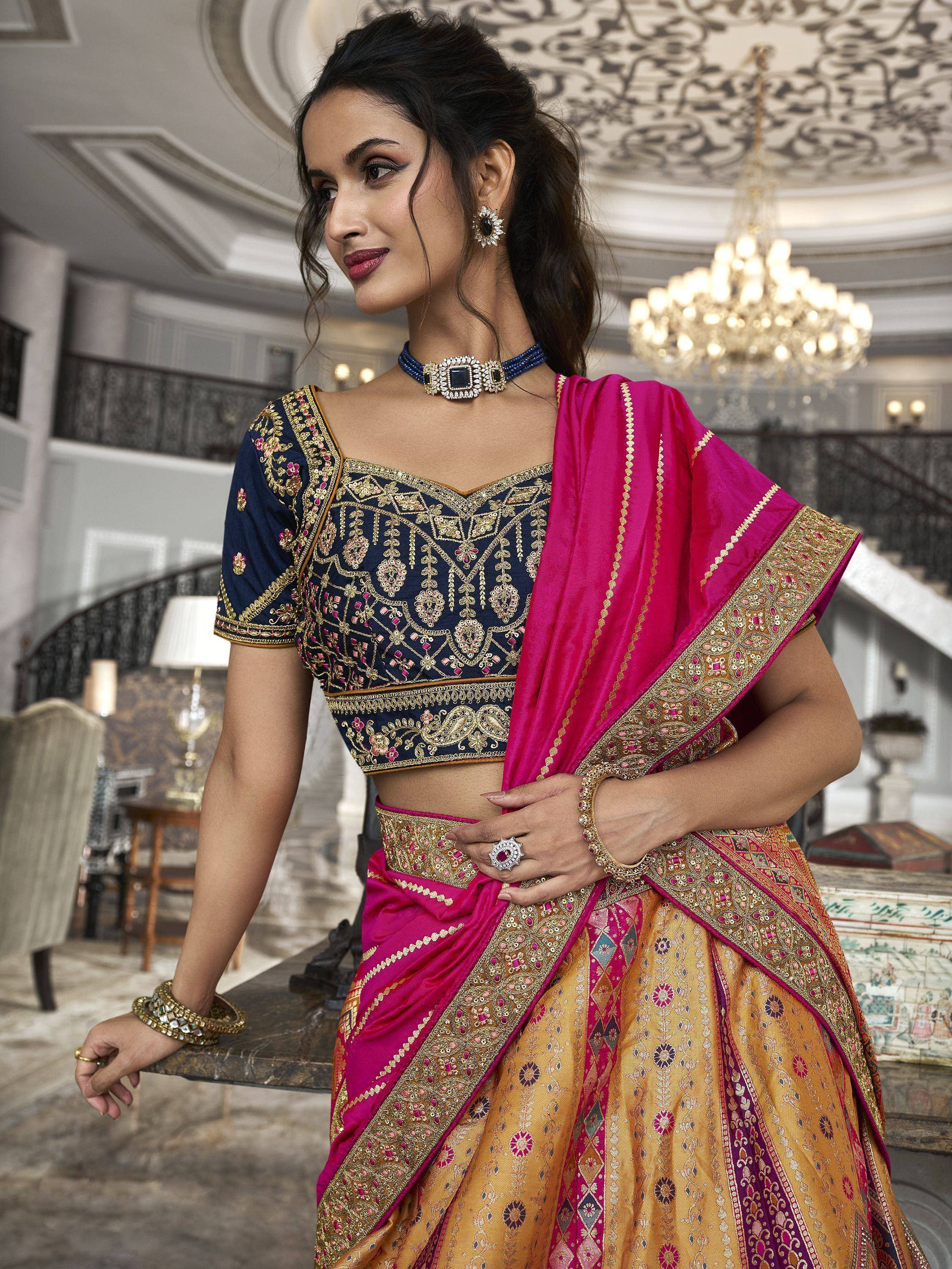 Elegant Indian lehenga choli with navy blue embroidered blouse and pink-gold skirt, perfect for weddings and festivals.