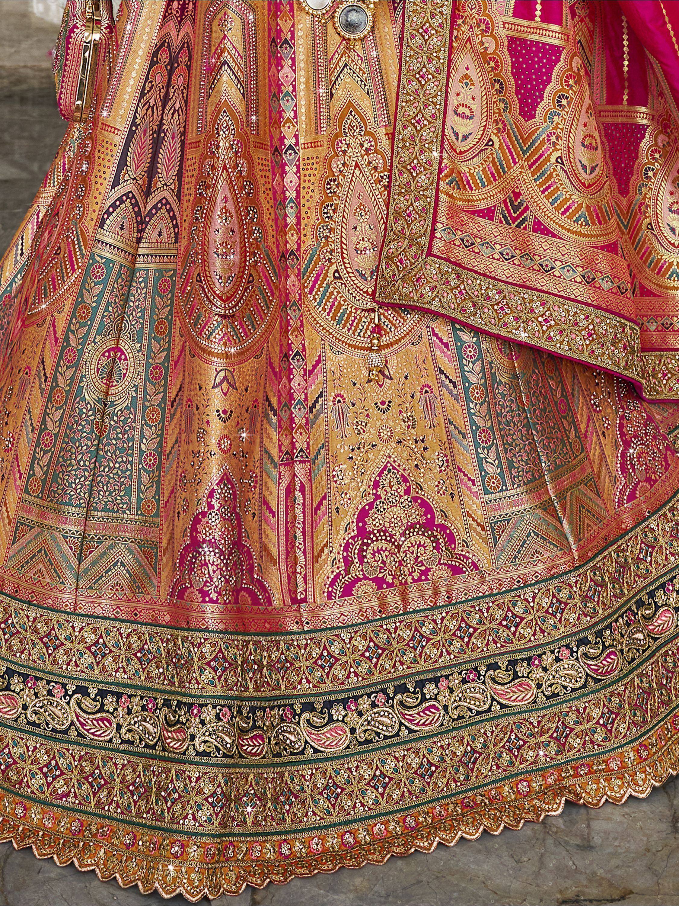 Luxury Indian lehenga choli with intricate gold embroidery and vibrant pink, gold, and teal patterns.