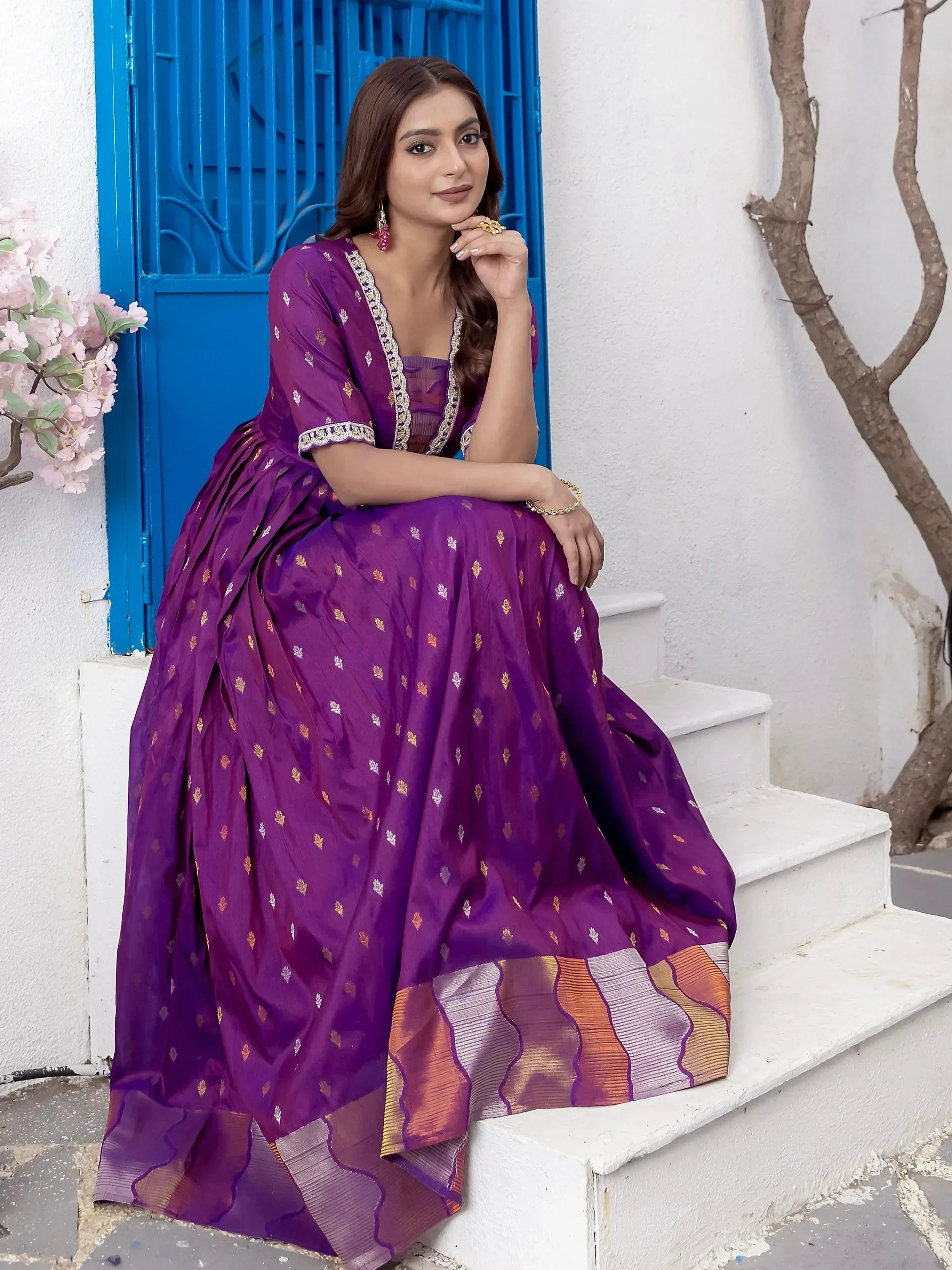 Purple ethnic gown with gold motifs and contrast border, styled for Indian occasions
