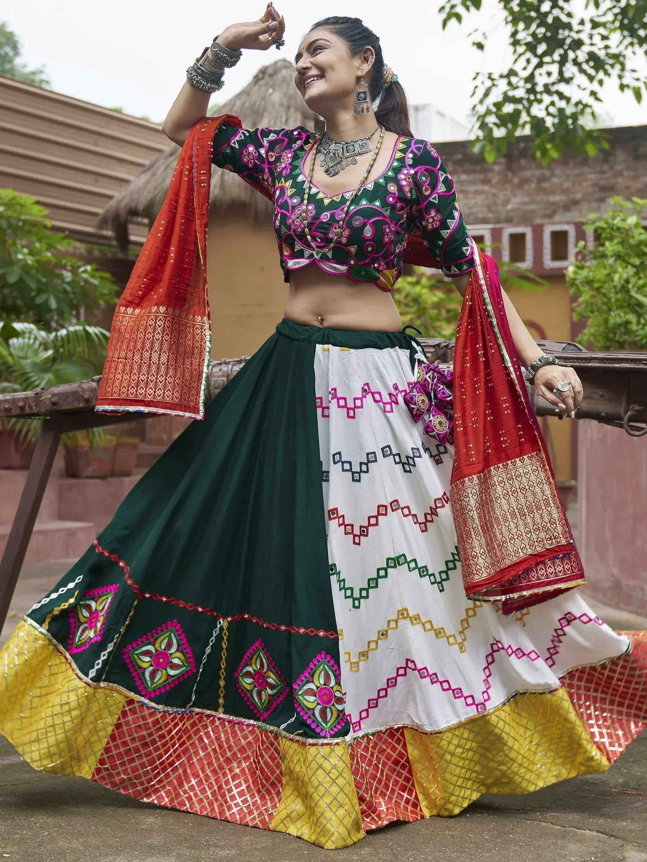 Woman in vibrant green and white embroidered lehenga choli with red dupatta, traditional Indian ethnic wear