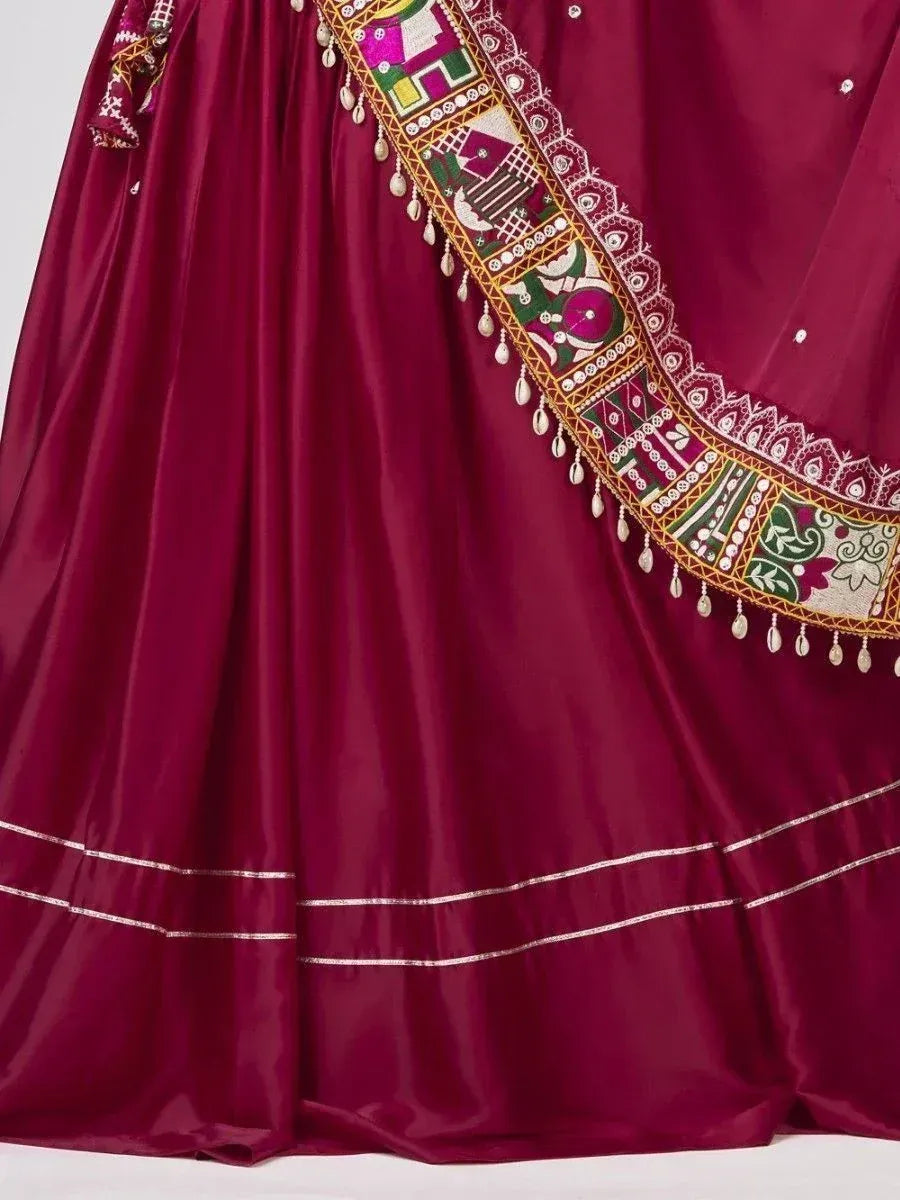 Rich maroon lehenga with colorful embroidered border and tassels, ideal for Indian ethnic wear