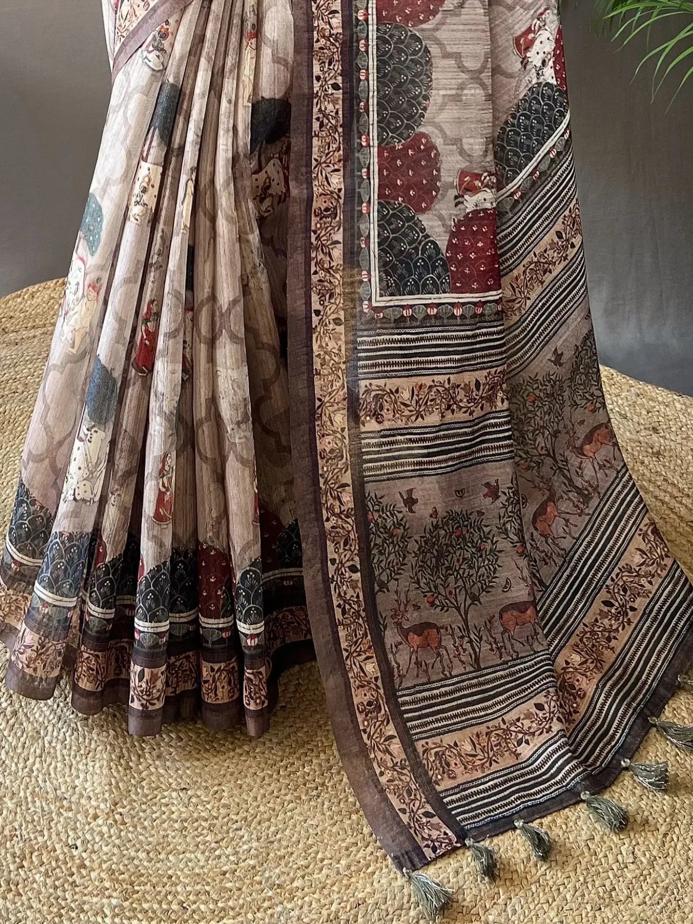 Elegant Indian saree with intricate forest & deer print, ethnic motifs, and tassels, perfect for traditional occasions.