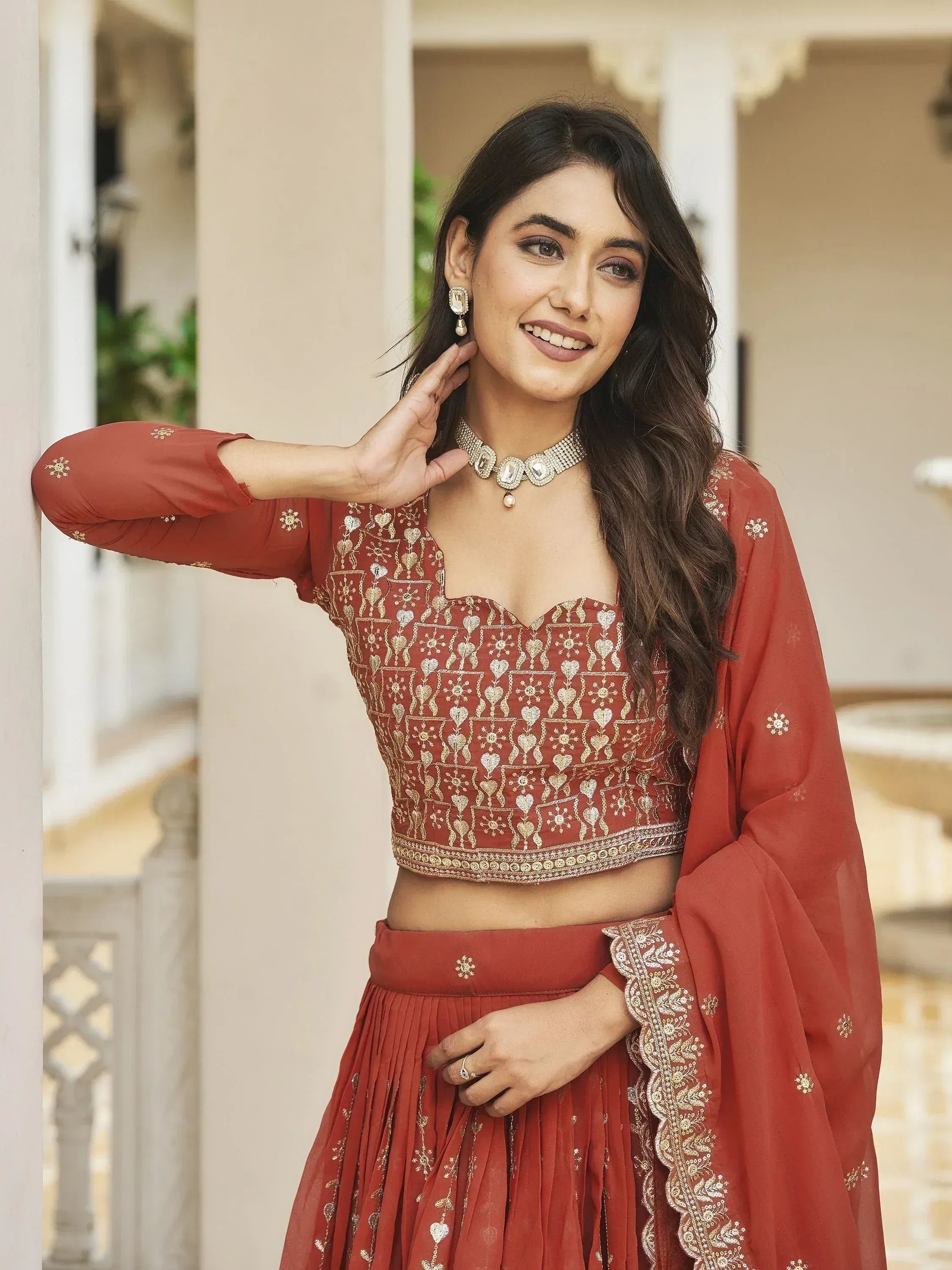 Woman in maroon embroidered lehenga choli with gold detailing, perfect for Indian ethnic wear occasions