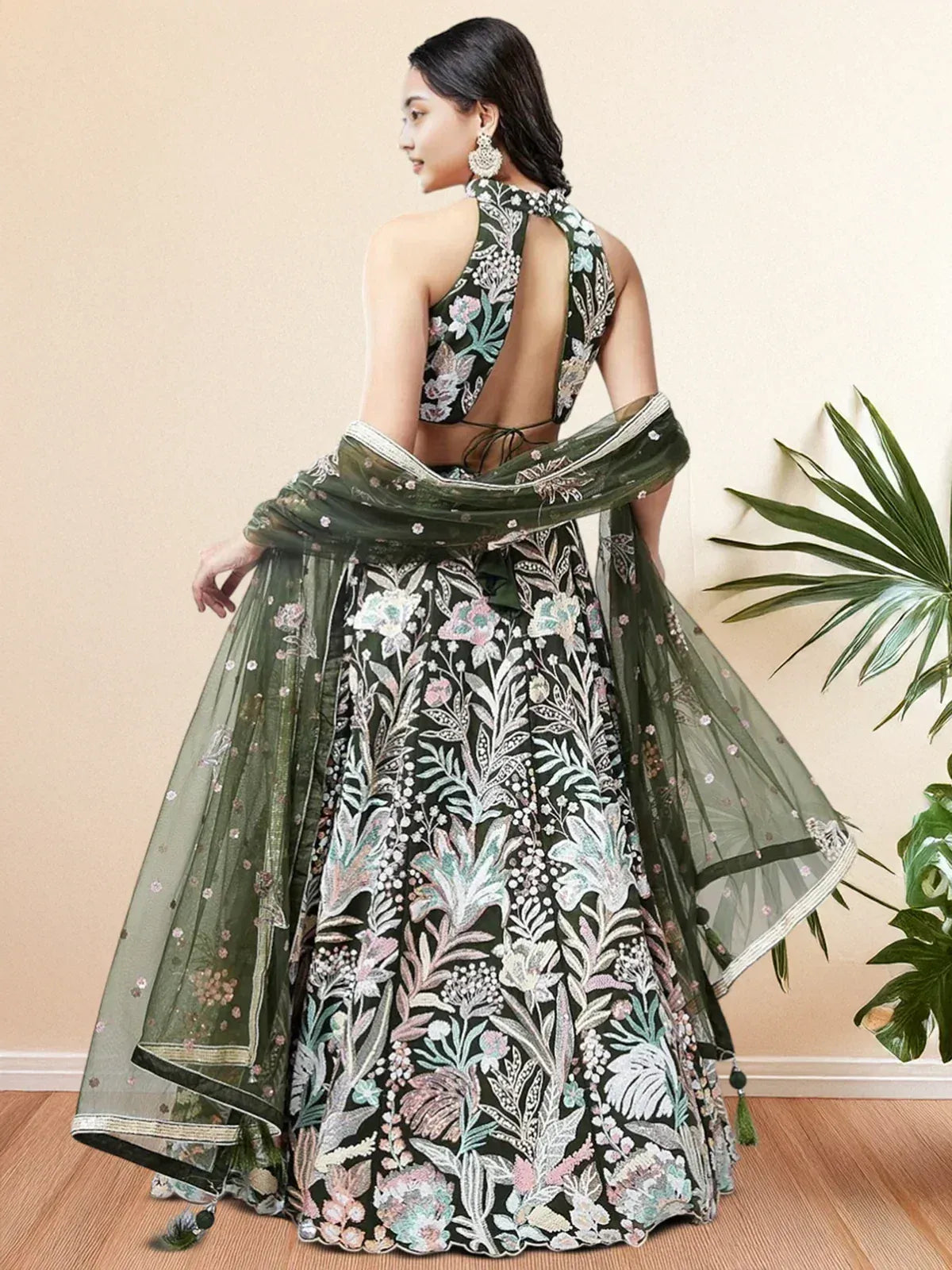 Elegant green floral embroidered lehenga choli with backless blouse and sheer dupatta, perfect for Indian ethnic wear.