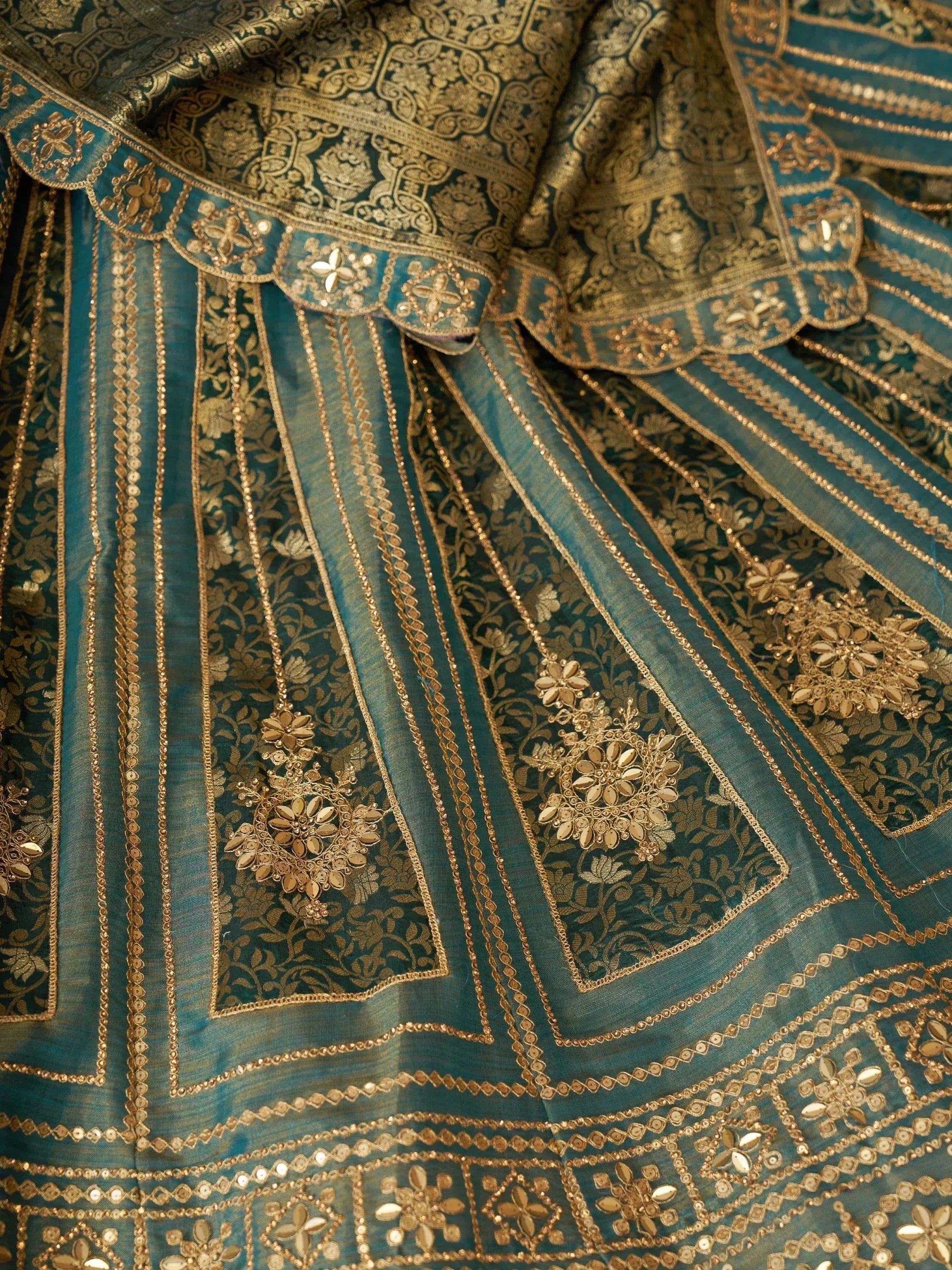 Teal and gold embroidered lehenga choli with intricate floral zari work and mirror detailing