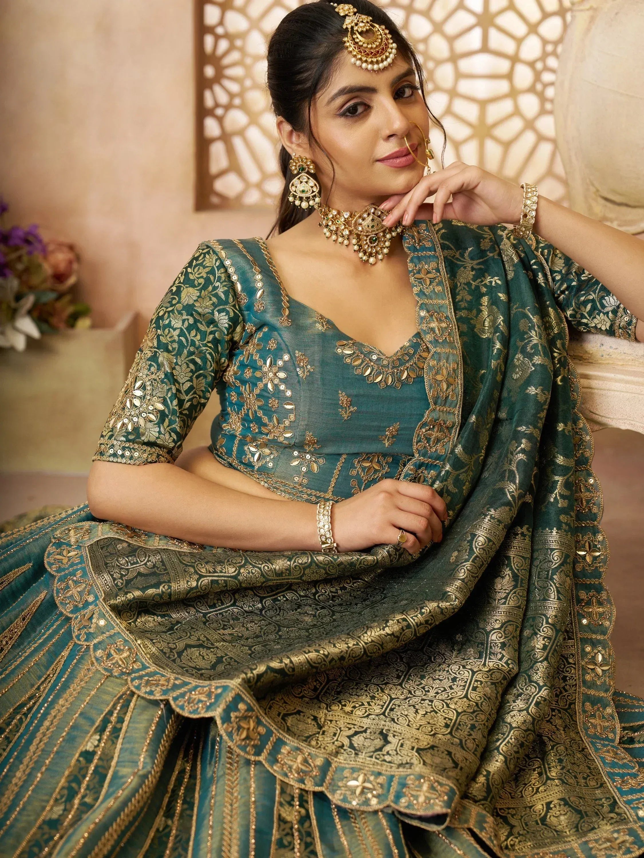 Teal and gold embroidered lehenga choli with traditional Indian jewelry for festive occasions