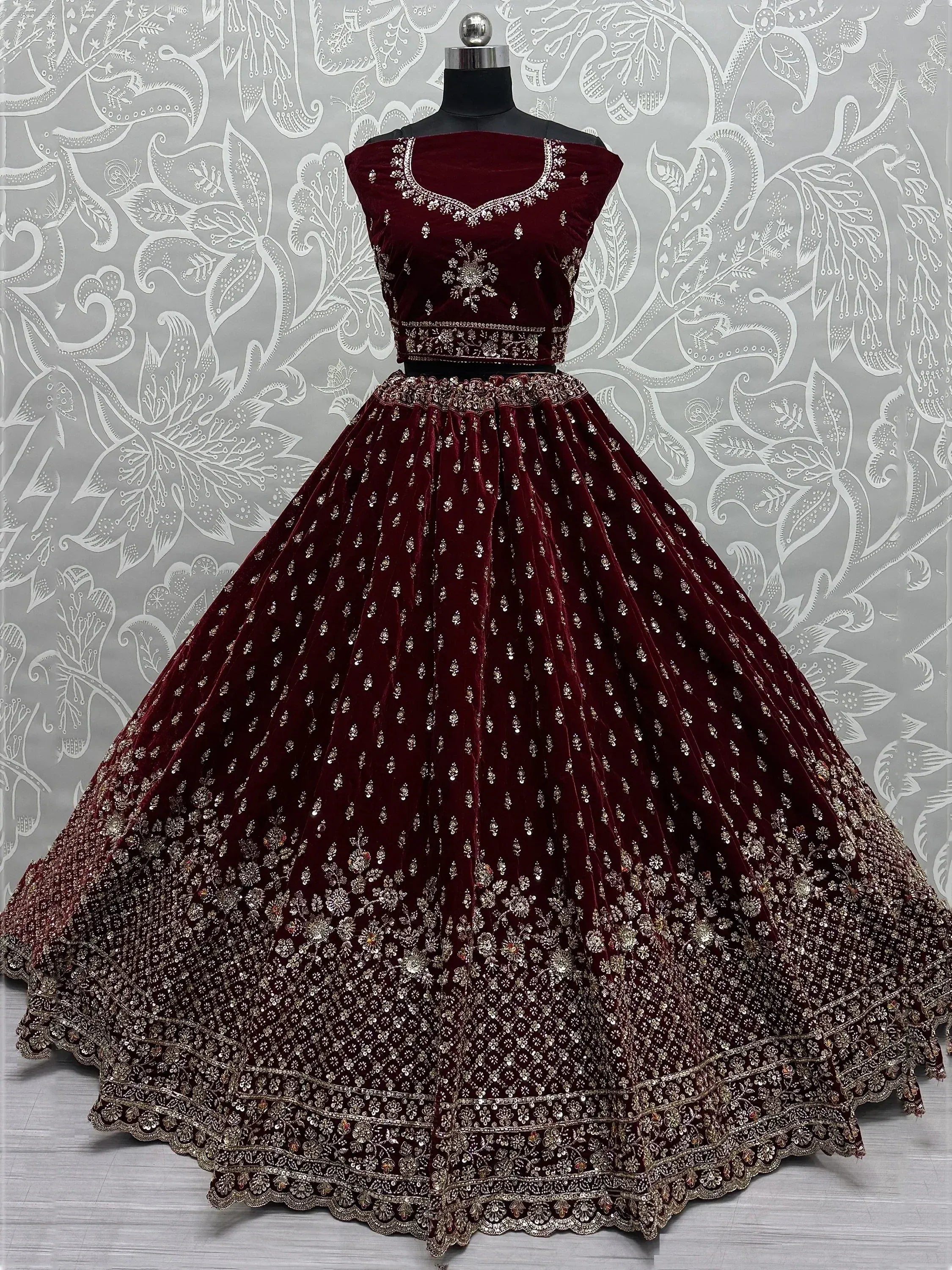 Maroon velvet designer lehenga choli with heavy silver embroidery, perfect for Indian weddings and festive occasions.