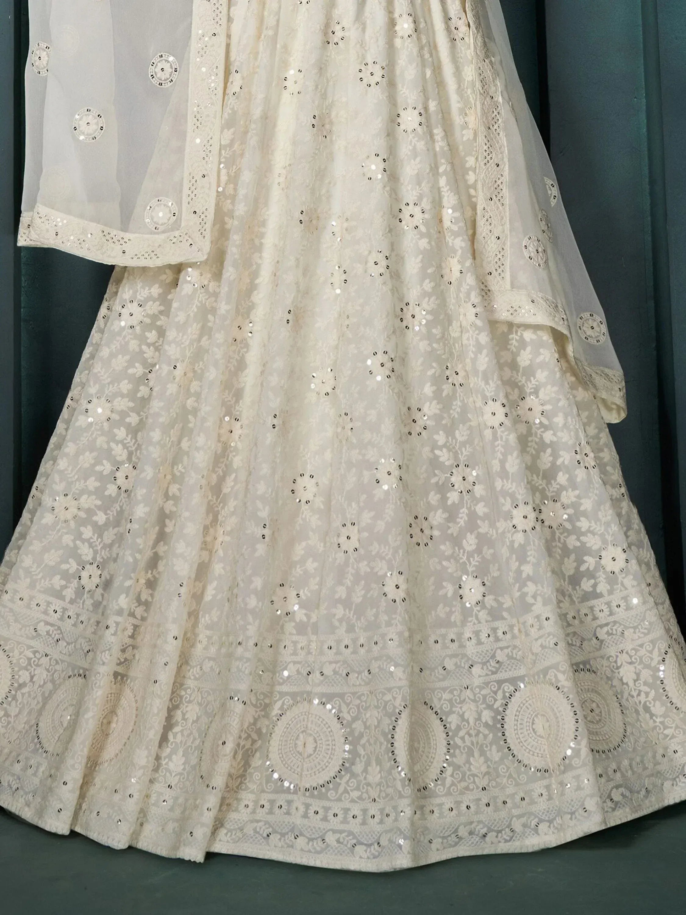 White embroidered lehenga choli with floral patterns and mirror work, perfect for Indian ethnic wear.