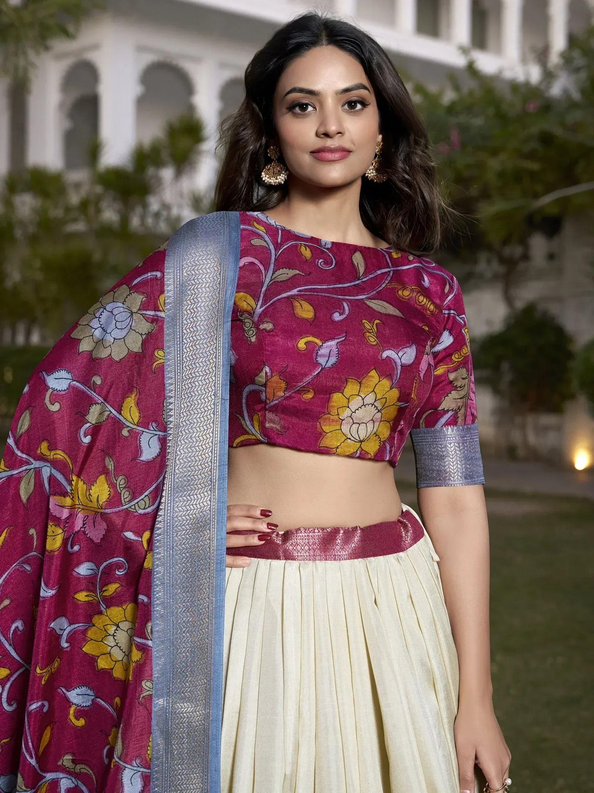 Woman in floral print magenta crop top with cream pleated skirt and blue dupatta, Indian ethnic wear