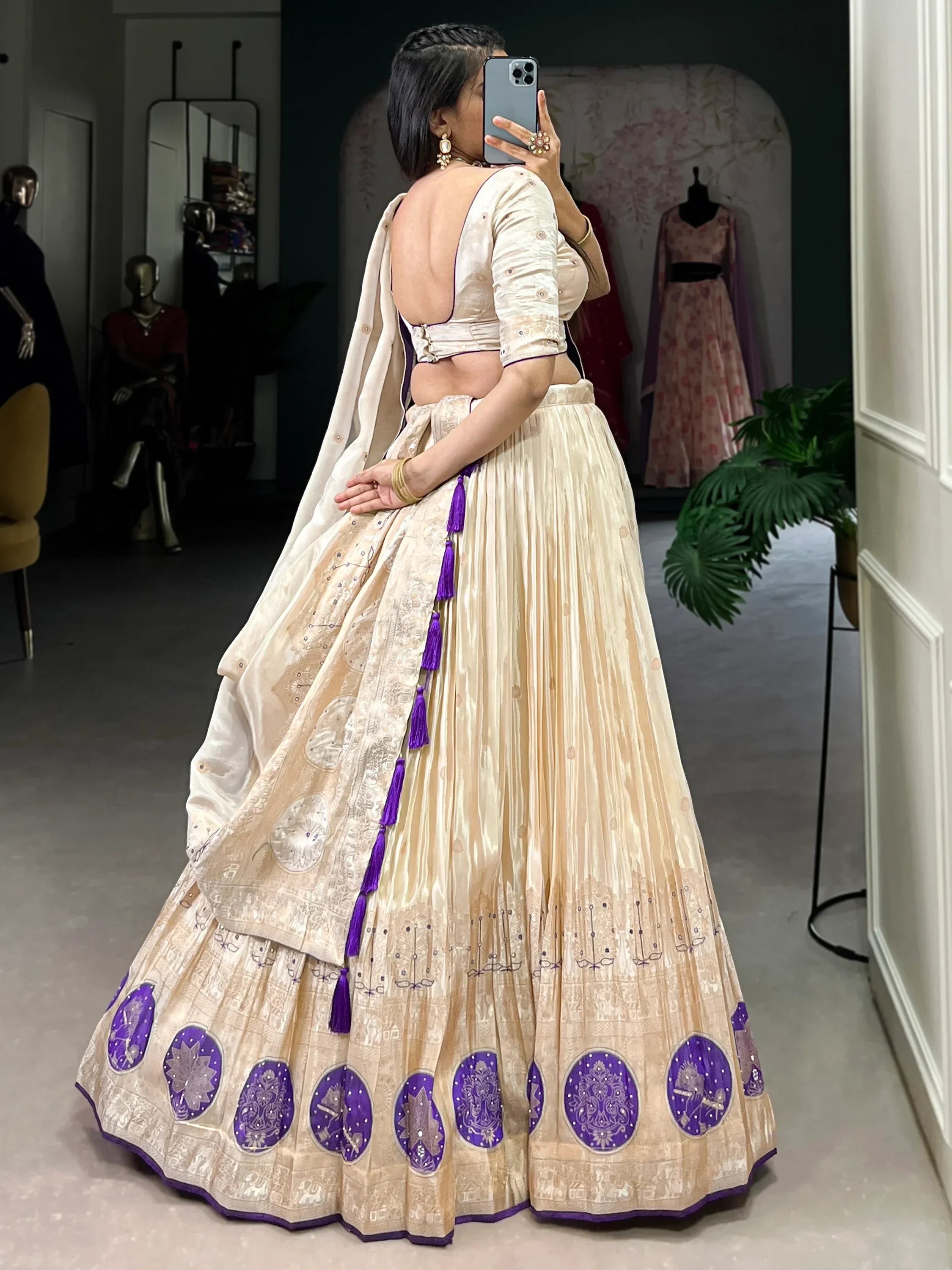 Cream and purple designer lehenga choli with embroidered motifs and tassels, back view