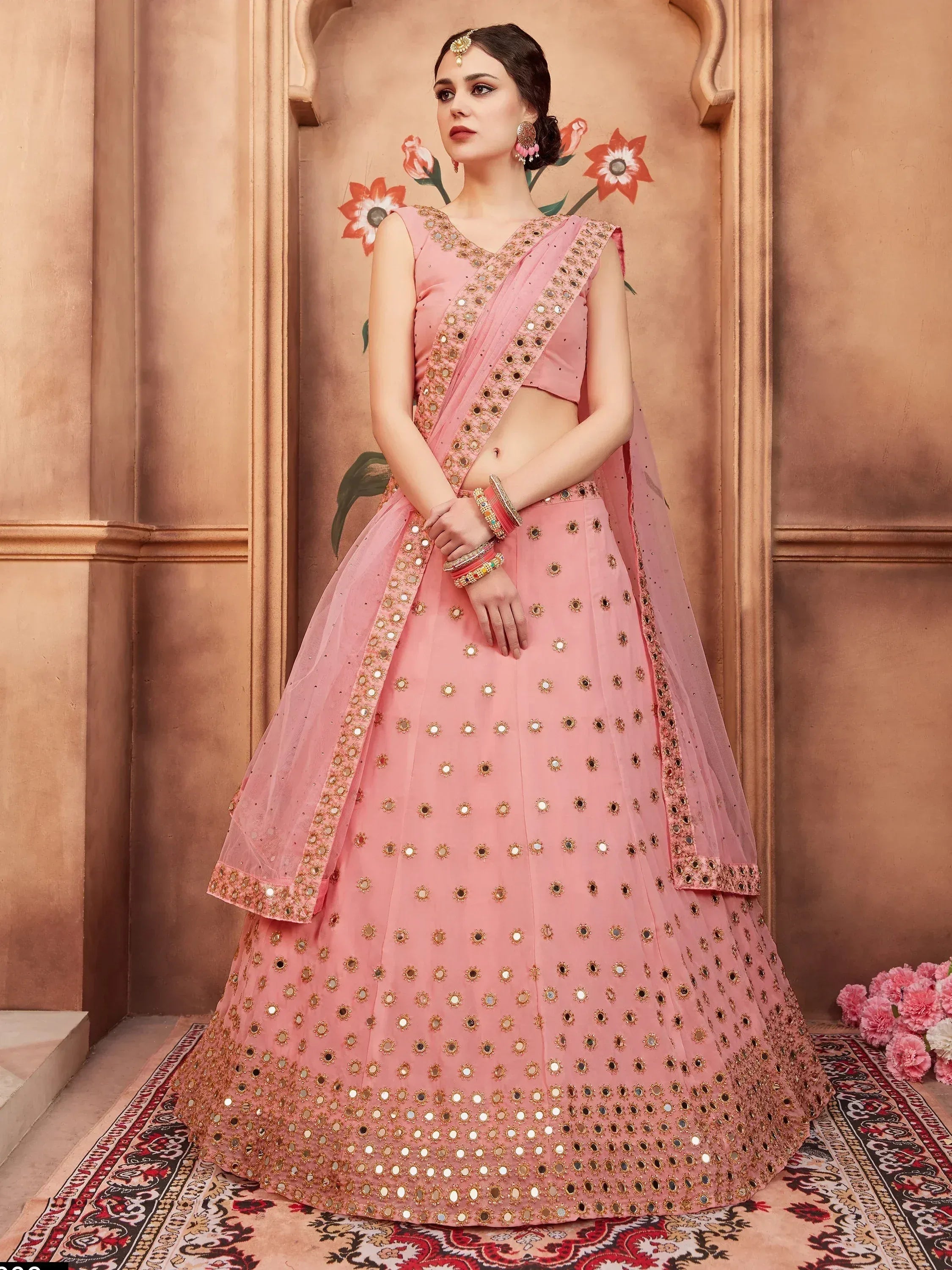 Pink mirror-work lehenga choli with gold embroidery, perfect for Indian weddings and festive occasions.