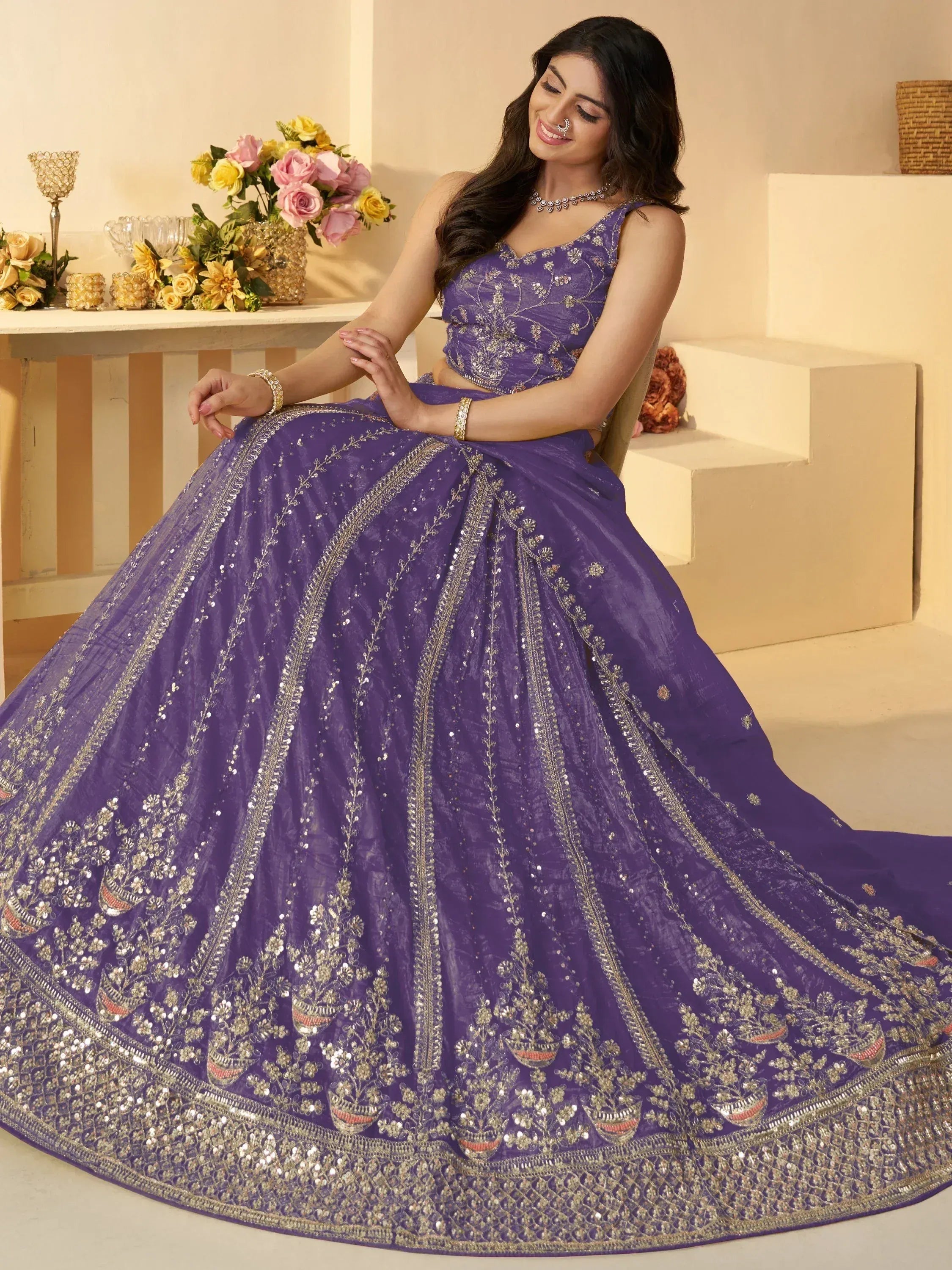 Purple designer lehenga choli with intricate gold embroidery and sequins, perfect for Indian weddings and festivals.