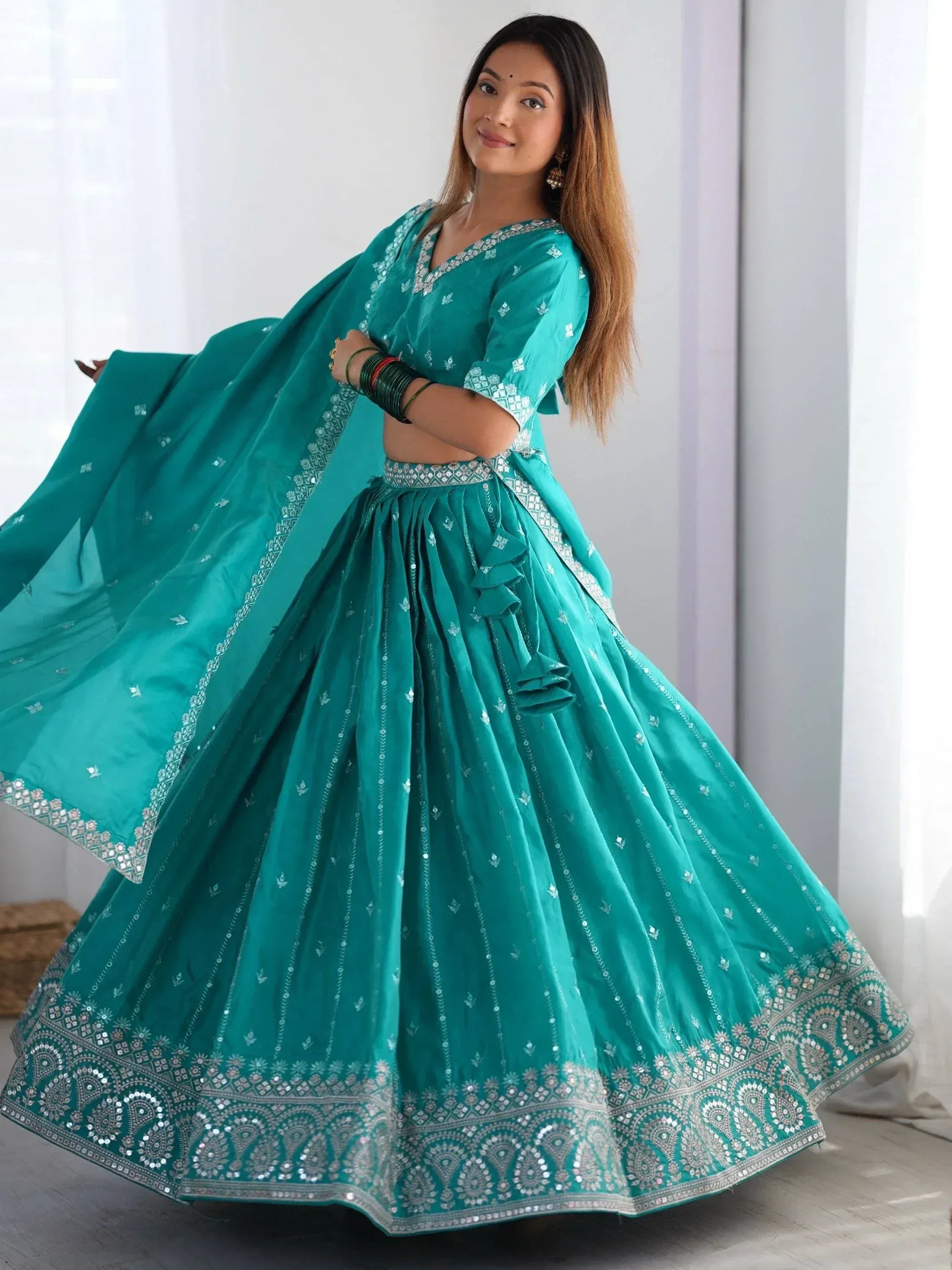 Teal designer lehenga choli with silver embroidery and mirror work, perfect for Indian ethnic wear.
