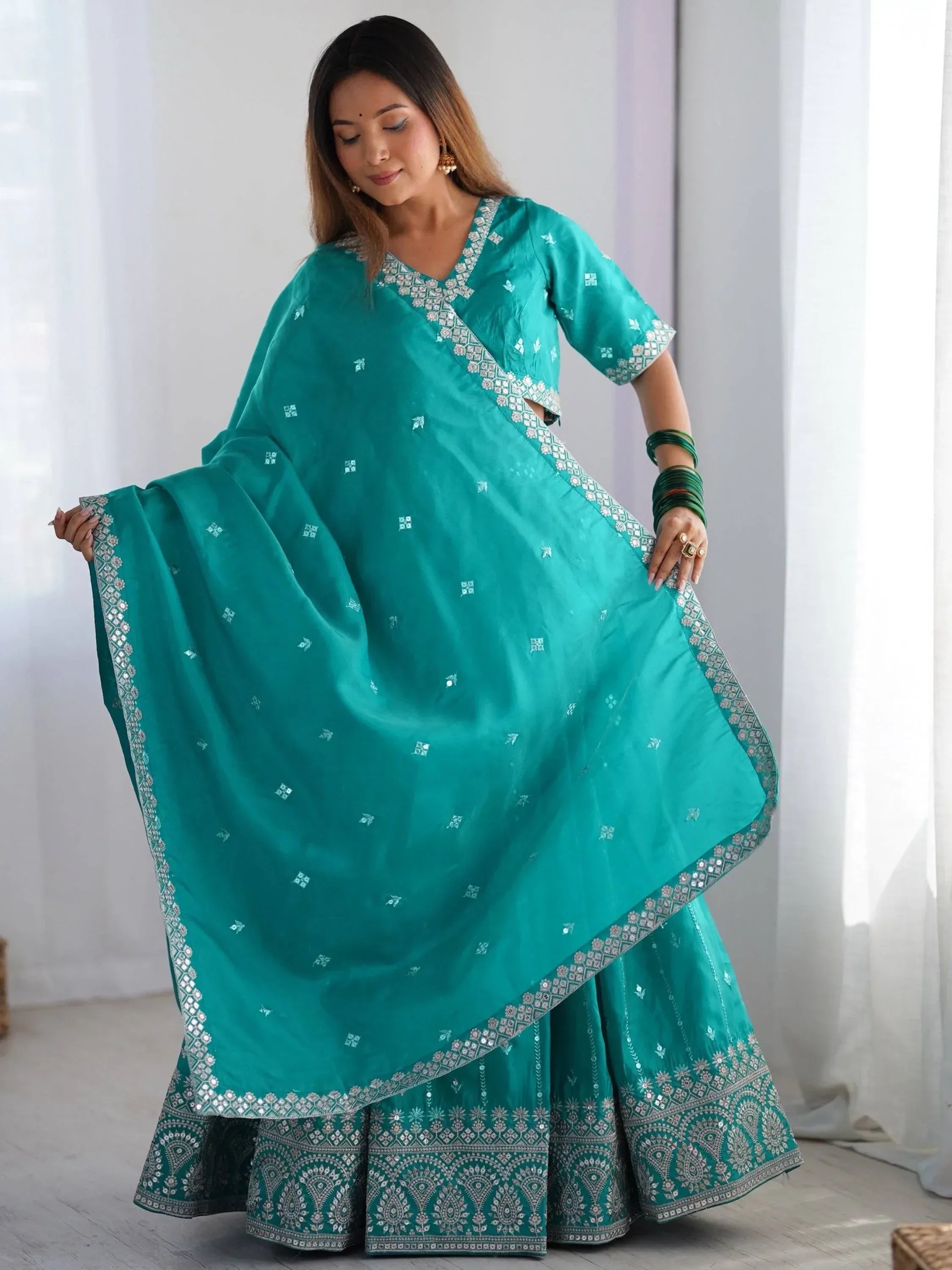 Teal green designer lehenga choli with mirror work and embroidery, perfect for Indian ethnic wear occasions