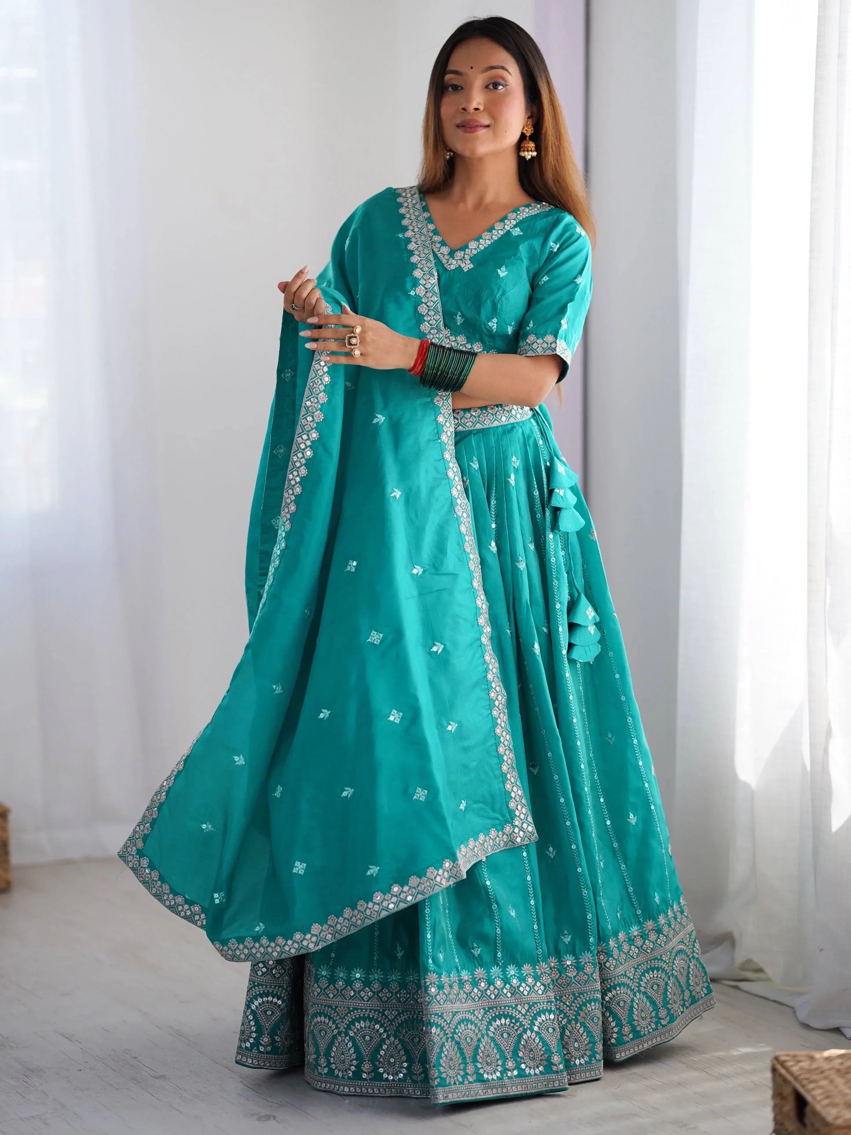 Teal green embroidered lehenga choli with mirror work, perfect for Indian ethnic wear and festive occasions.