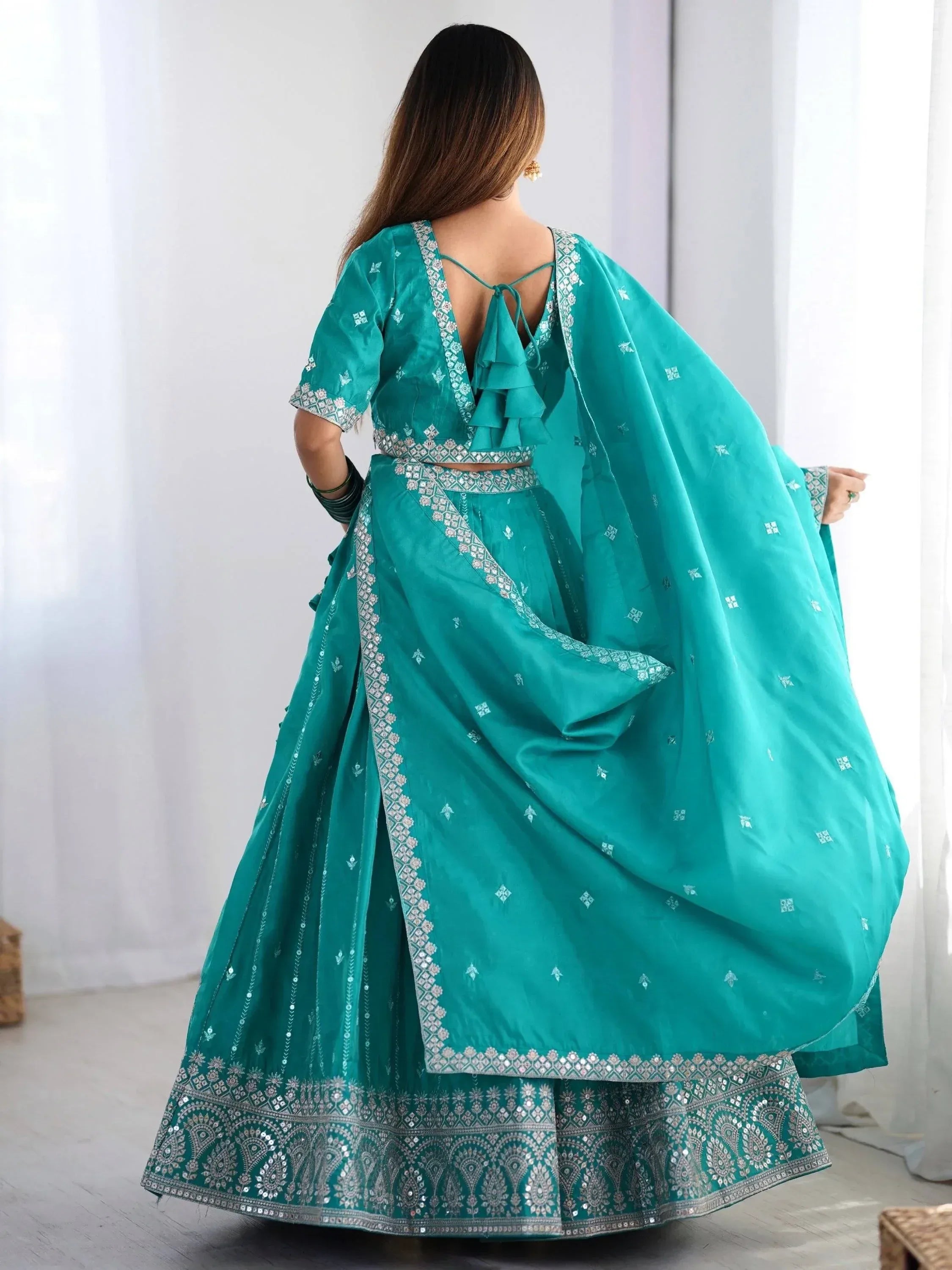 Teal lehenga choli with silver embroidery, ruffled back, and dupatta for Indian ethnic wear